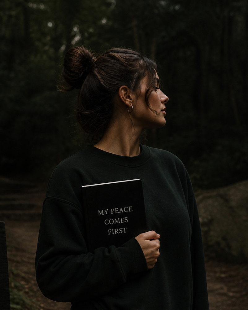 Woman holding a notebook that says “My Peace Comes First,” symbolizing boundaries, self-worth, and emotional sovereignty after toxic love.