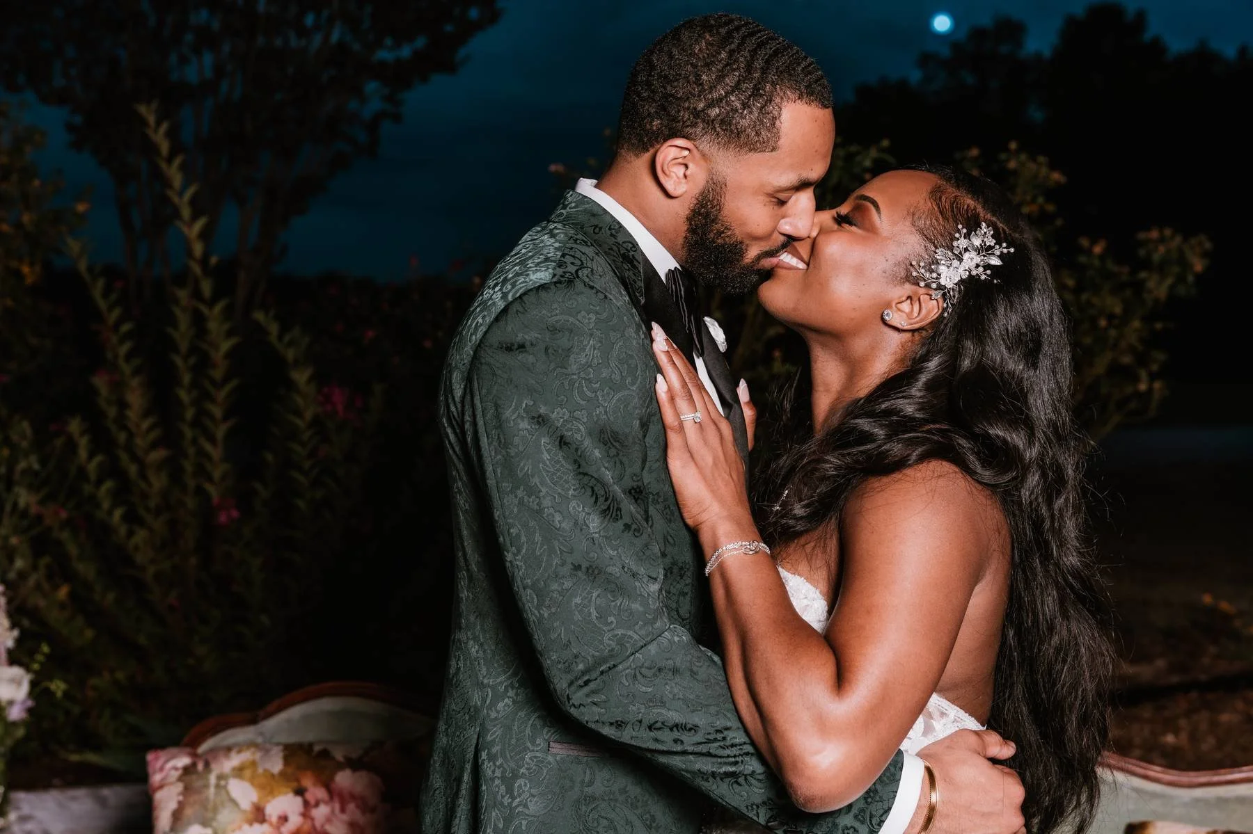 Romantic nighttime wedding portrait of a bride and groom at Blackberry Ridge in Georgia, captured under the stars with dramatic lighting, an emerald patterned tuxedo, and an elegant strapless wedding gown.