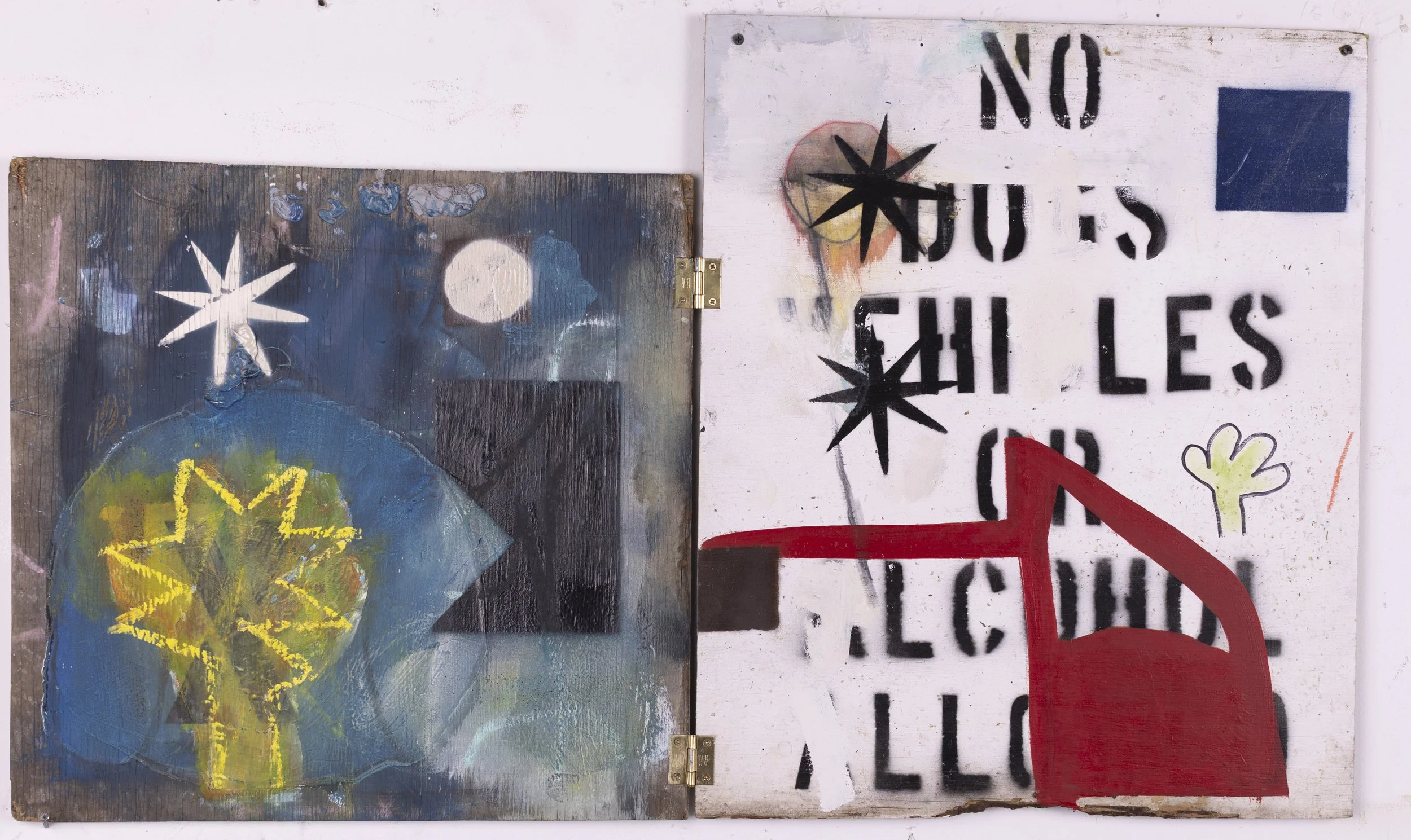 Two paintings mounted side by side on a wall. The left painting depicts abstract shapes and patterns with bright colors, including a glowing yellow star-like shape and a blue circular form. The right painting features textual elements with the words 