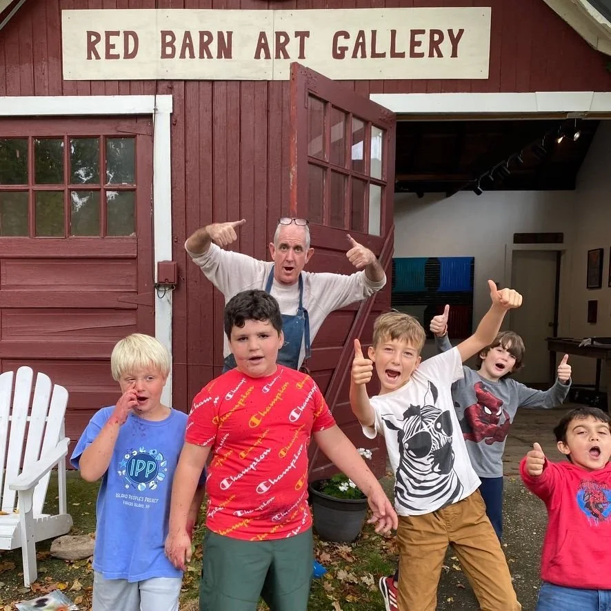 Group of children with Charles Thomas O'Neil outside of the Red Barn Gallery during a school visit.