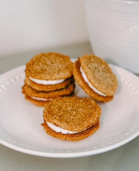 Fried oatmeal cookies with white filling on a white plate