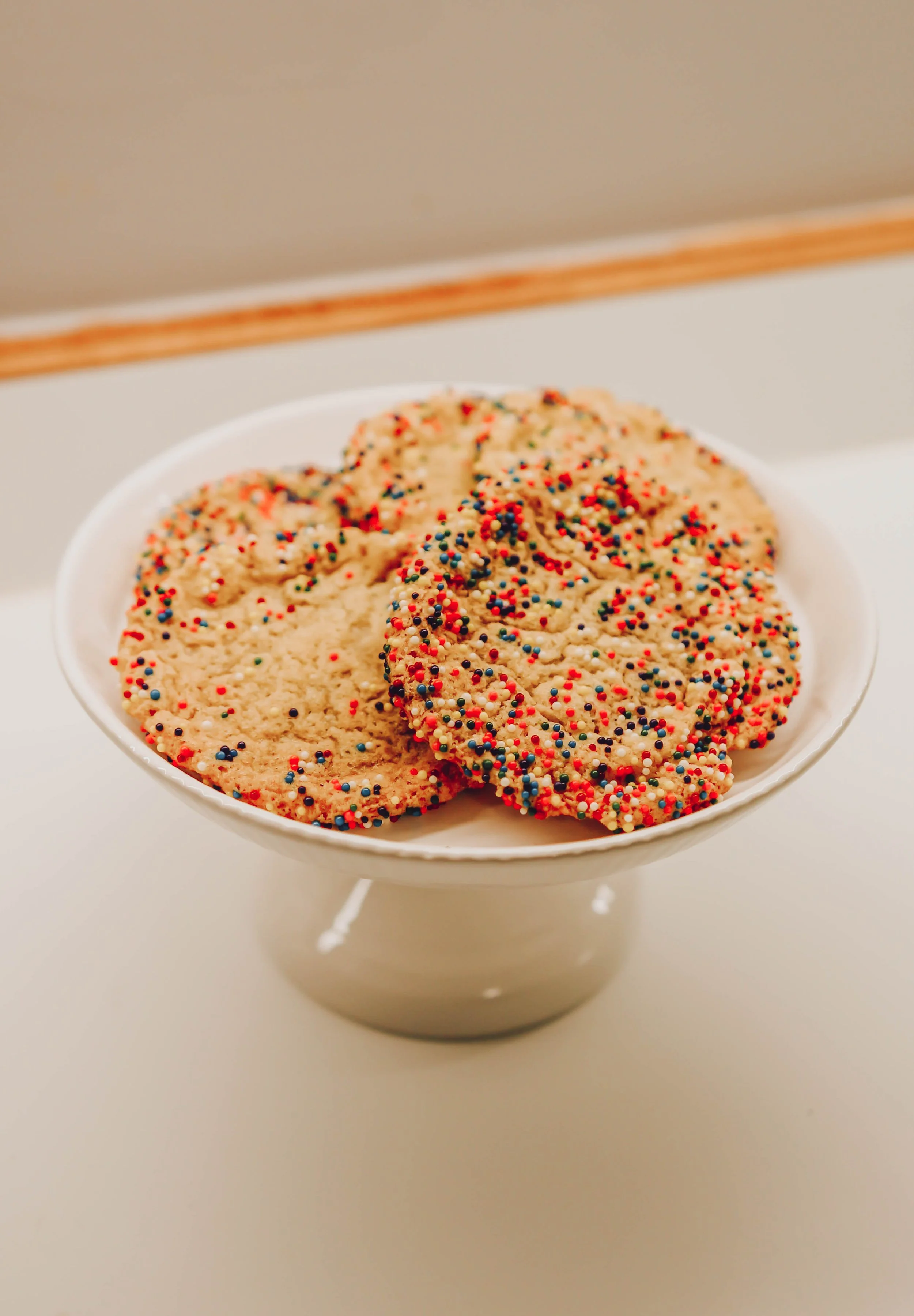 Plate of cookies with colorful sprinkles.