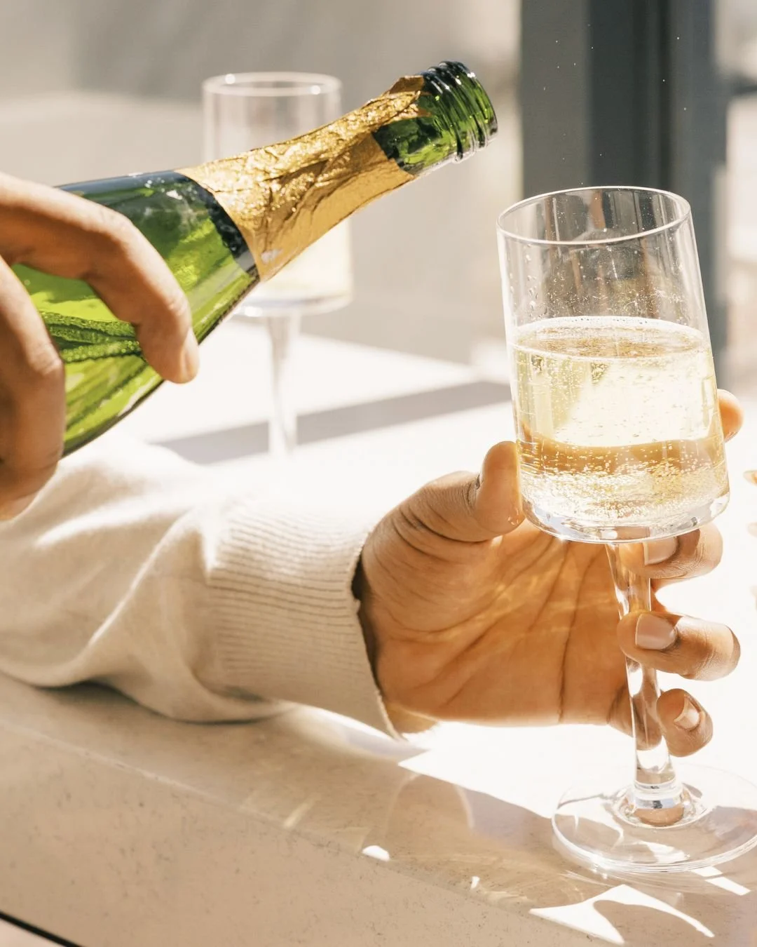 Person pouring champagne into a glass