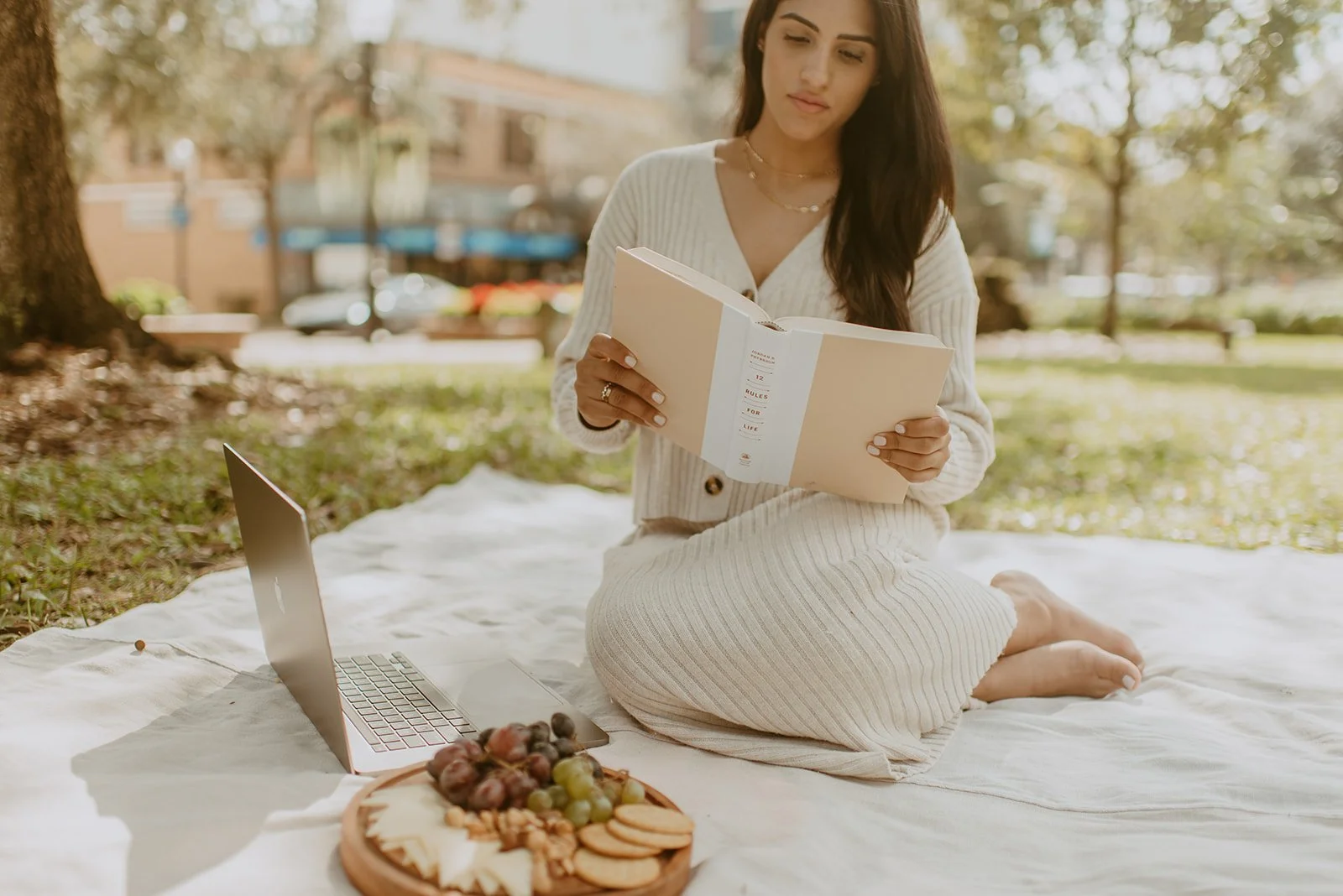 girl at the park, having a picnic reading a book