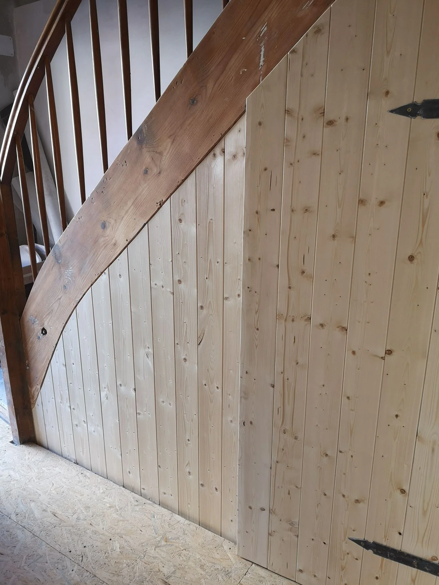 Holztreppe mit gelagertem Holz- und Spax-Schrauben, Geländer aus Holzstäben.