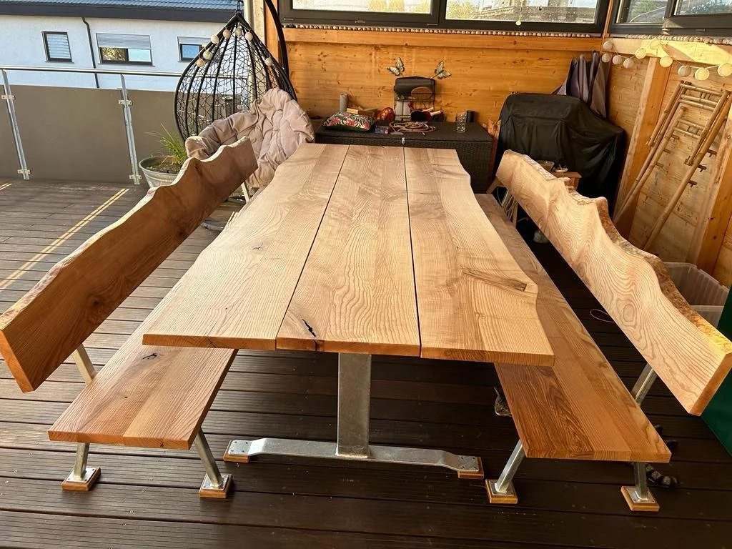 Lange Holztisch mit Rücken- und Sitzbänken auf einer Terrasse