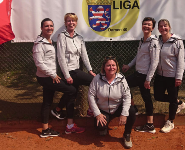 Fünf Frauen in Sportkleidung posieren vor einer Leinwand mit 'LIGA Damen 40' und einer Webseite im Hintergrund.