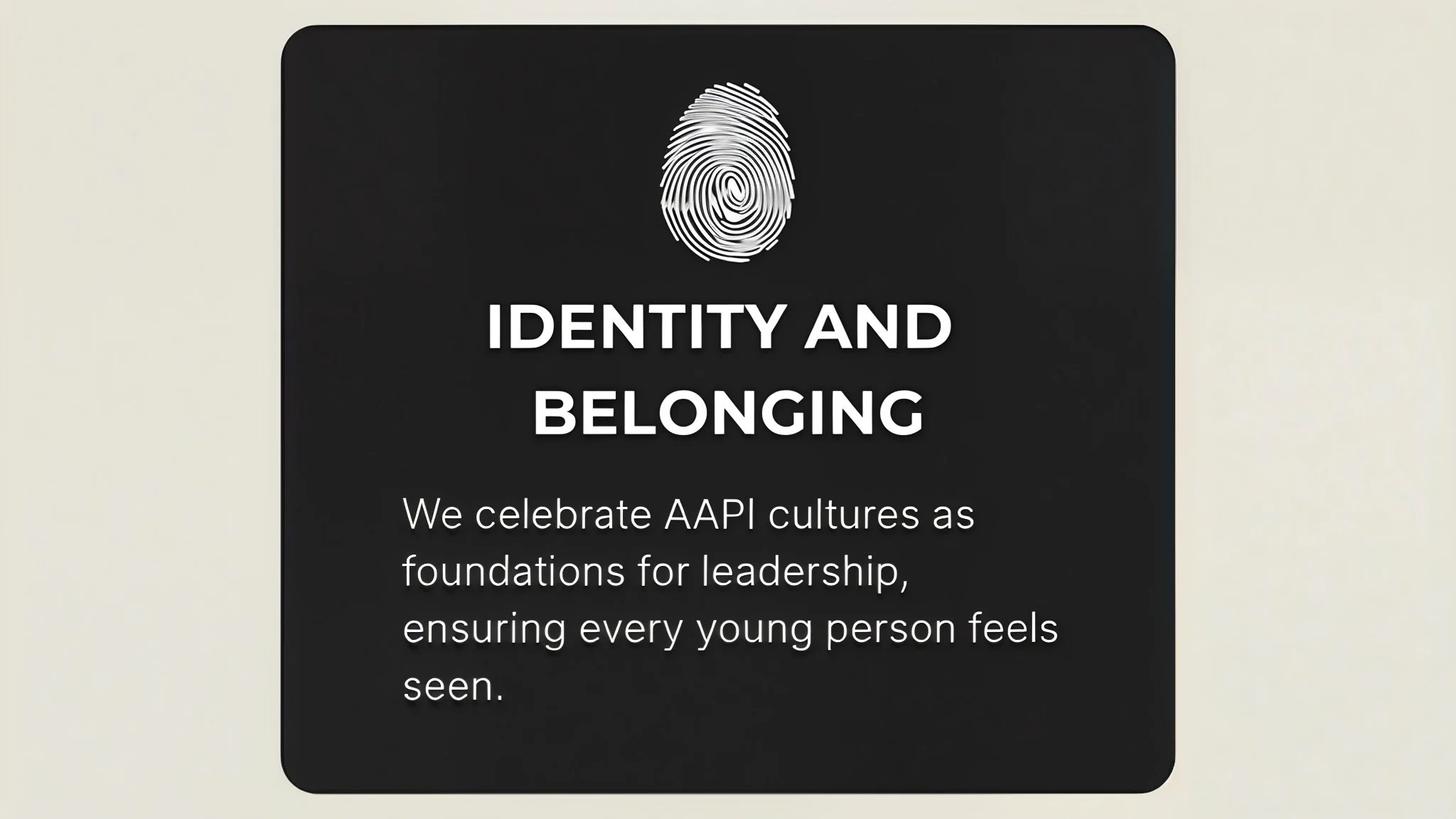 A sign with a fingerprint graphic at the top, and the words "Identity and Belonging" in bold, followed by a message about celebrating API cultures and promoting leadership for young people.