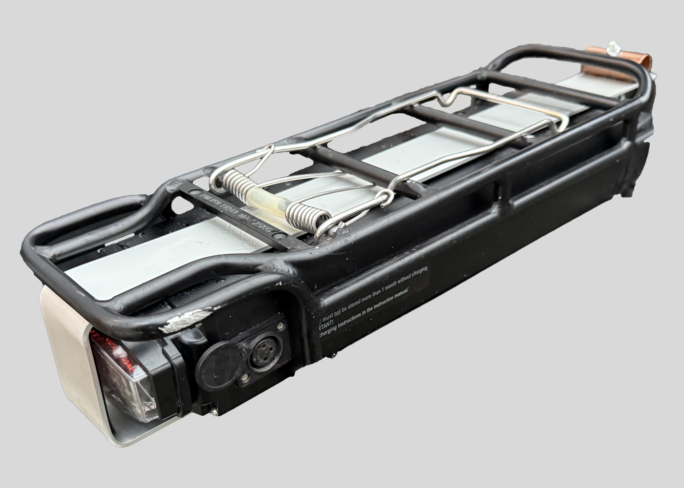 A battery from an electric bike with a prototype of the fingers off lock attached. The prototype is made of aluminium and covers the top, back and bottom of the battery to secure it in place.