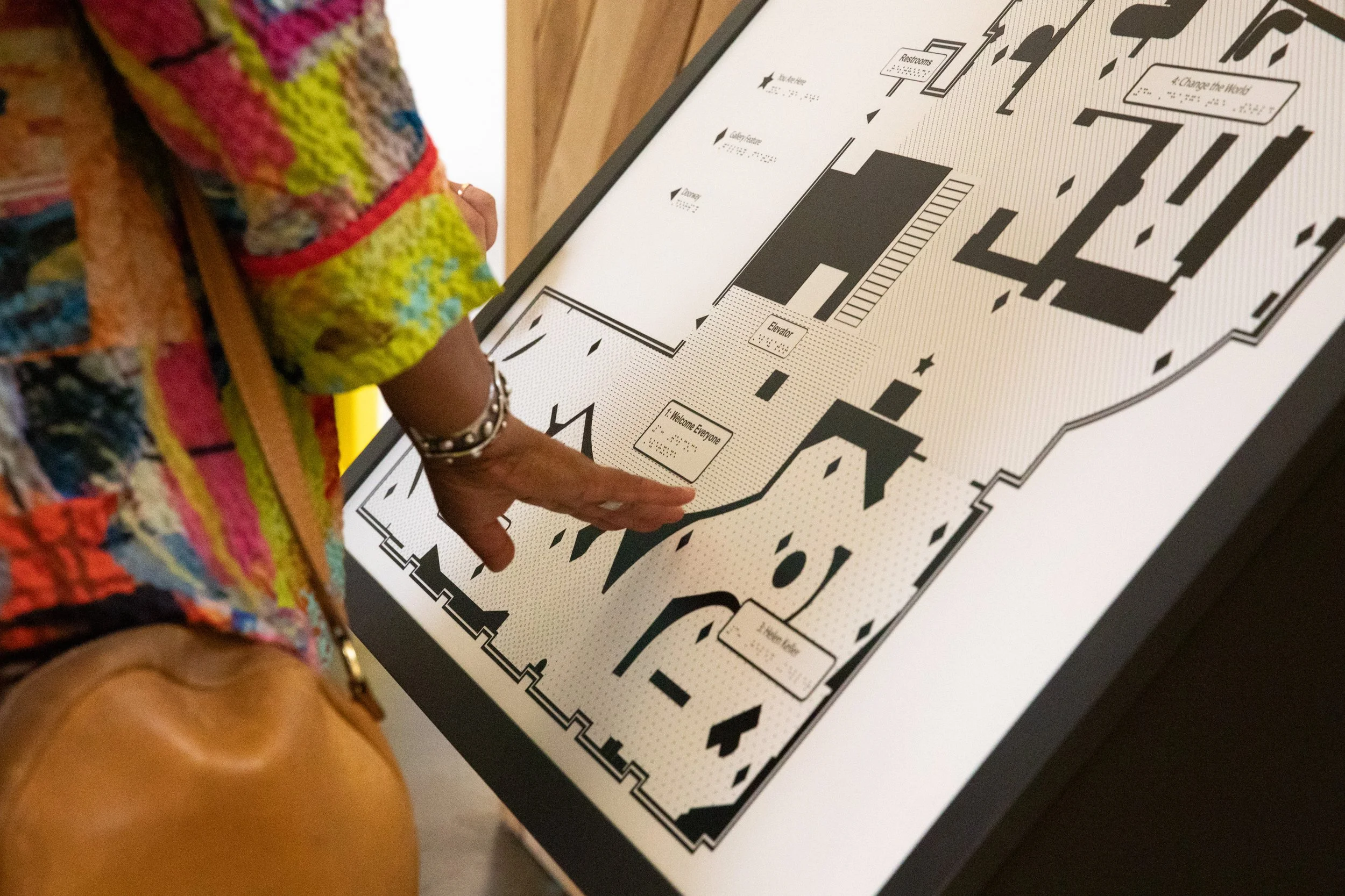 A woman runs her hand over a tactile map