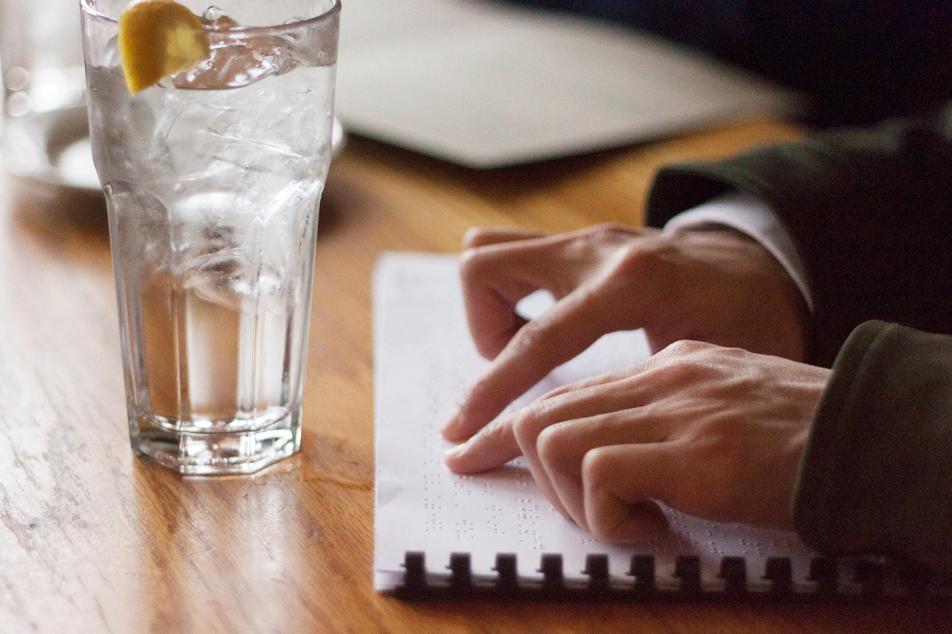 Hands are reading a braille menu