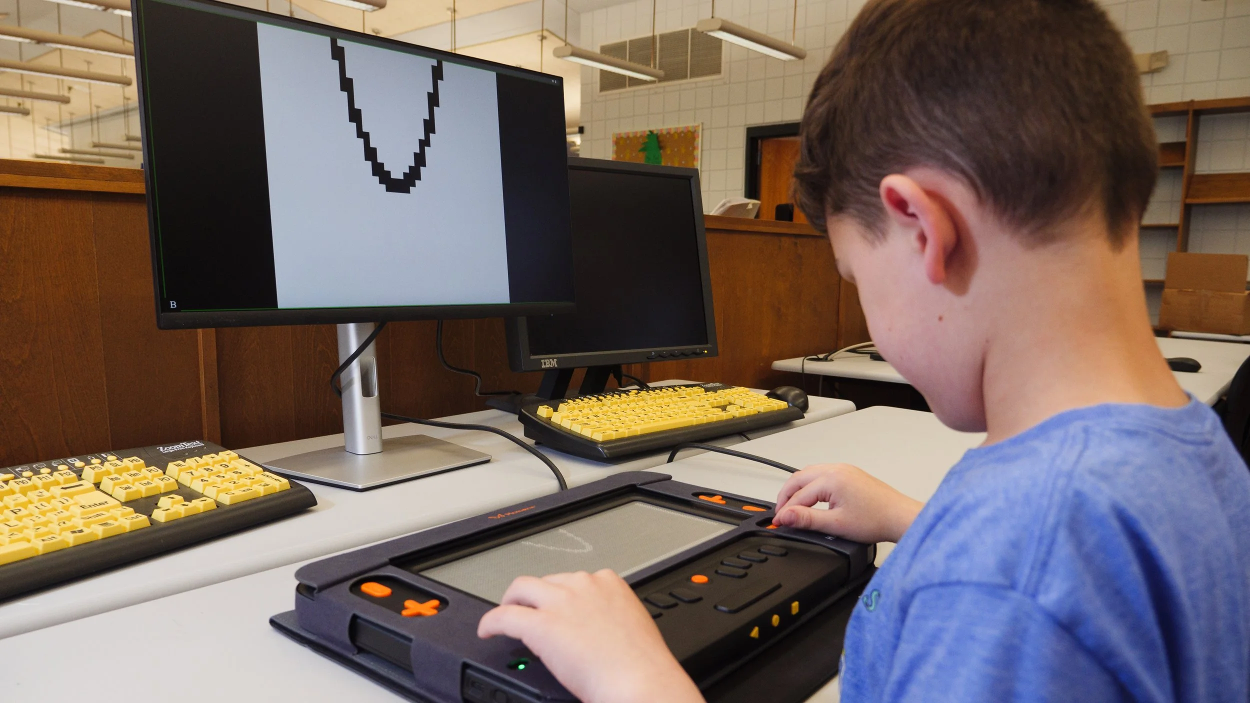 A young student uses a braille display to work through graphing