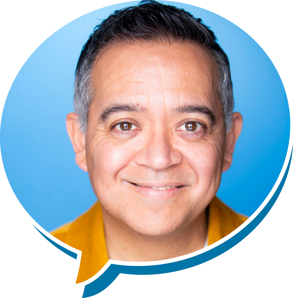 Close-up portrait of a smiling middle-aged man with short dark hair, brown eyes, and a light complexion against a blue background.