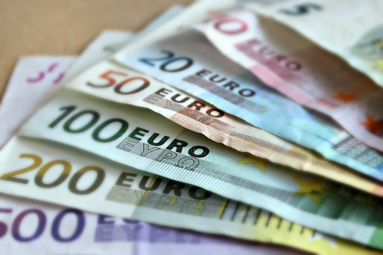 Various denominations of Euro banknotes including 500, 200, 100, 50, 20, and 10, arranged in a fan shape.