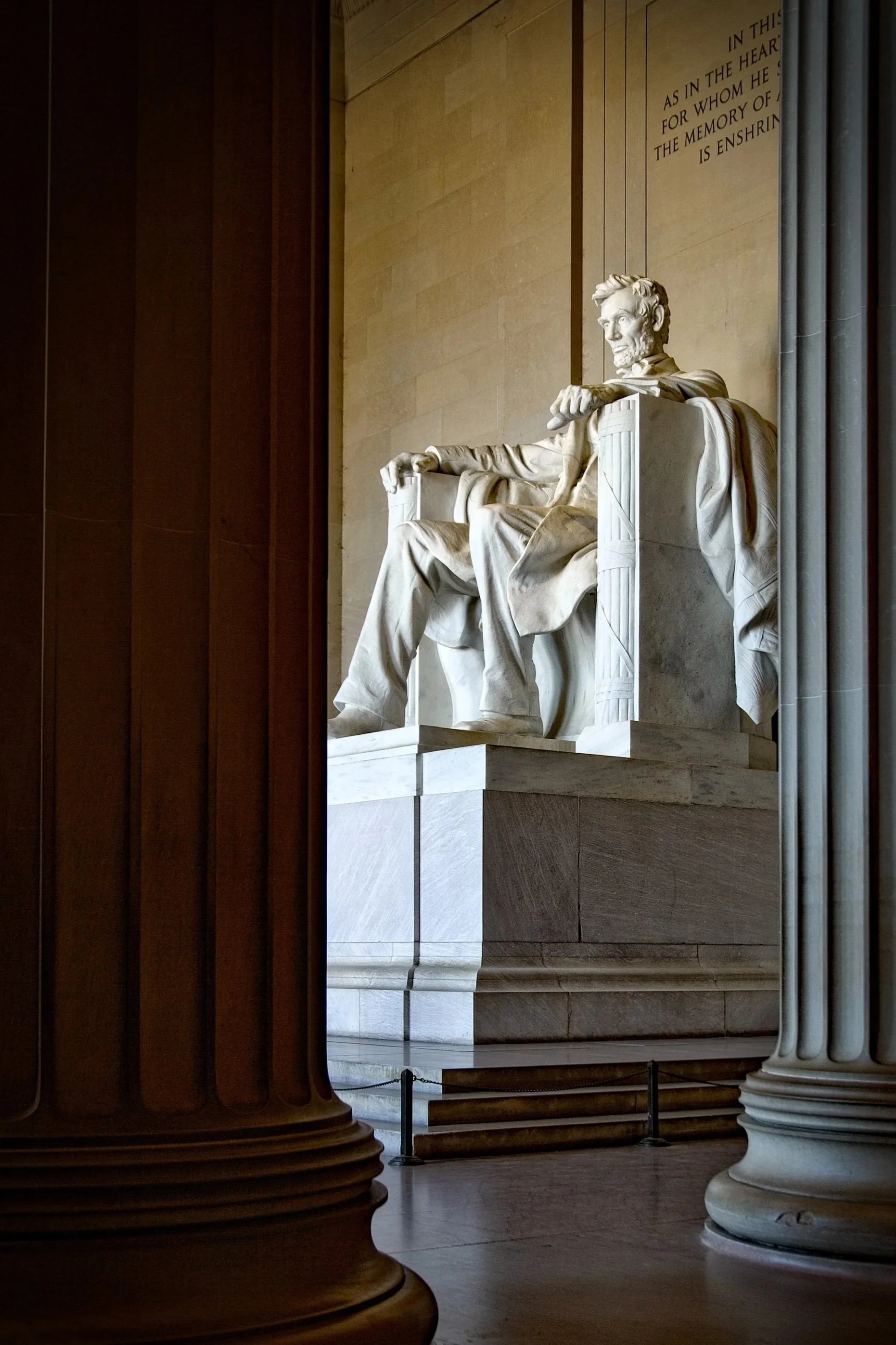 View of the Lincoln Memorial statue of Abraham Lincoln, seen through columns inside the memorial.