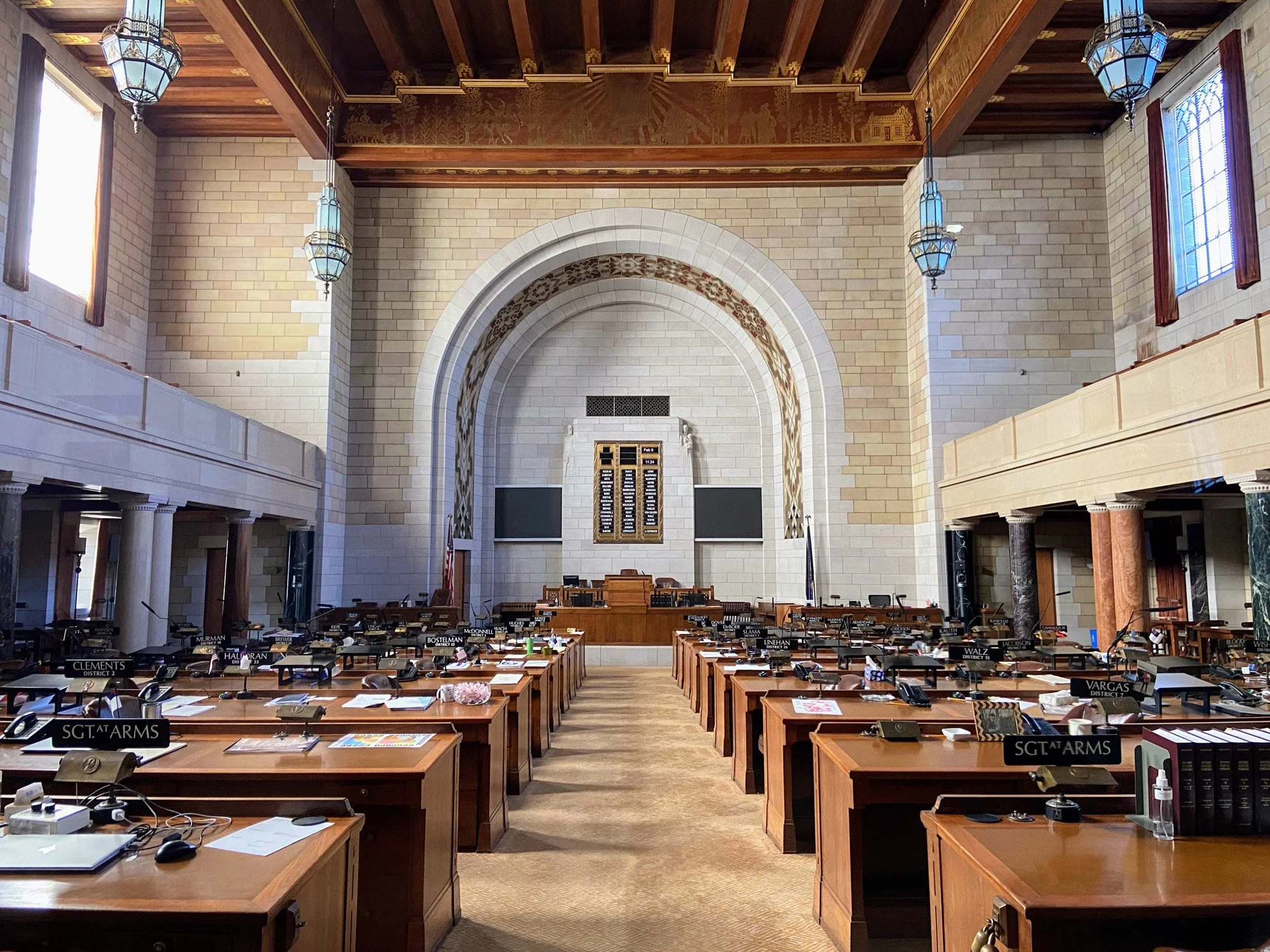 Central aisle between wooden desks in the Nebraska Capitol's legislative chamber.