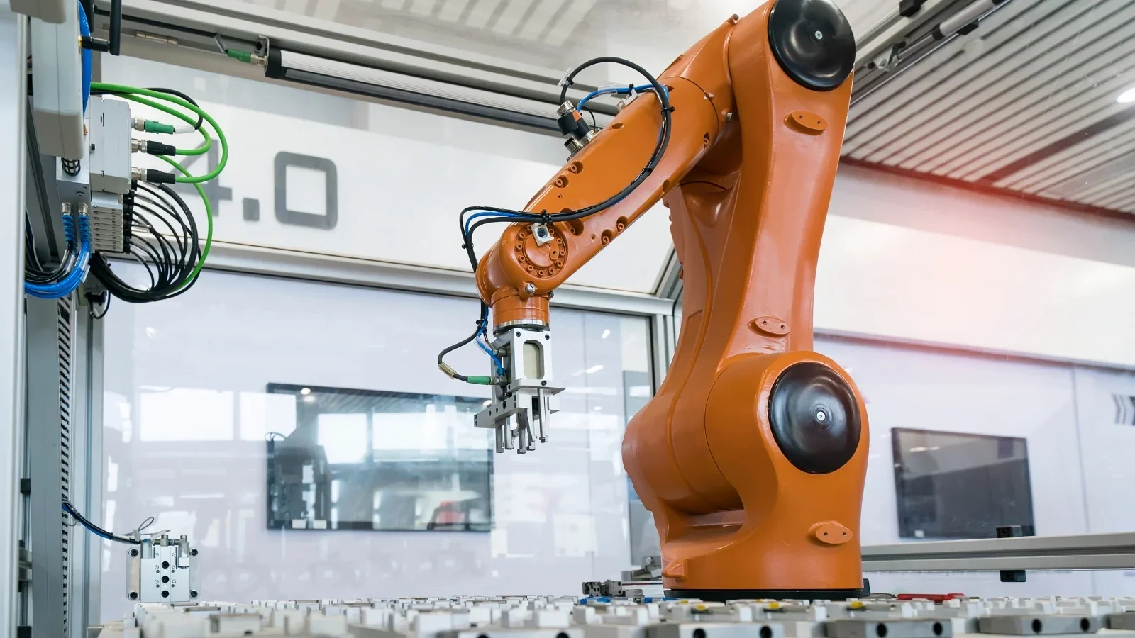 Industrial orange robotic arm inside a manufacturing or automation facility.