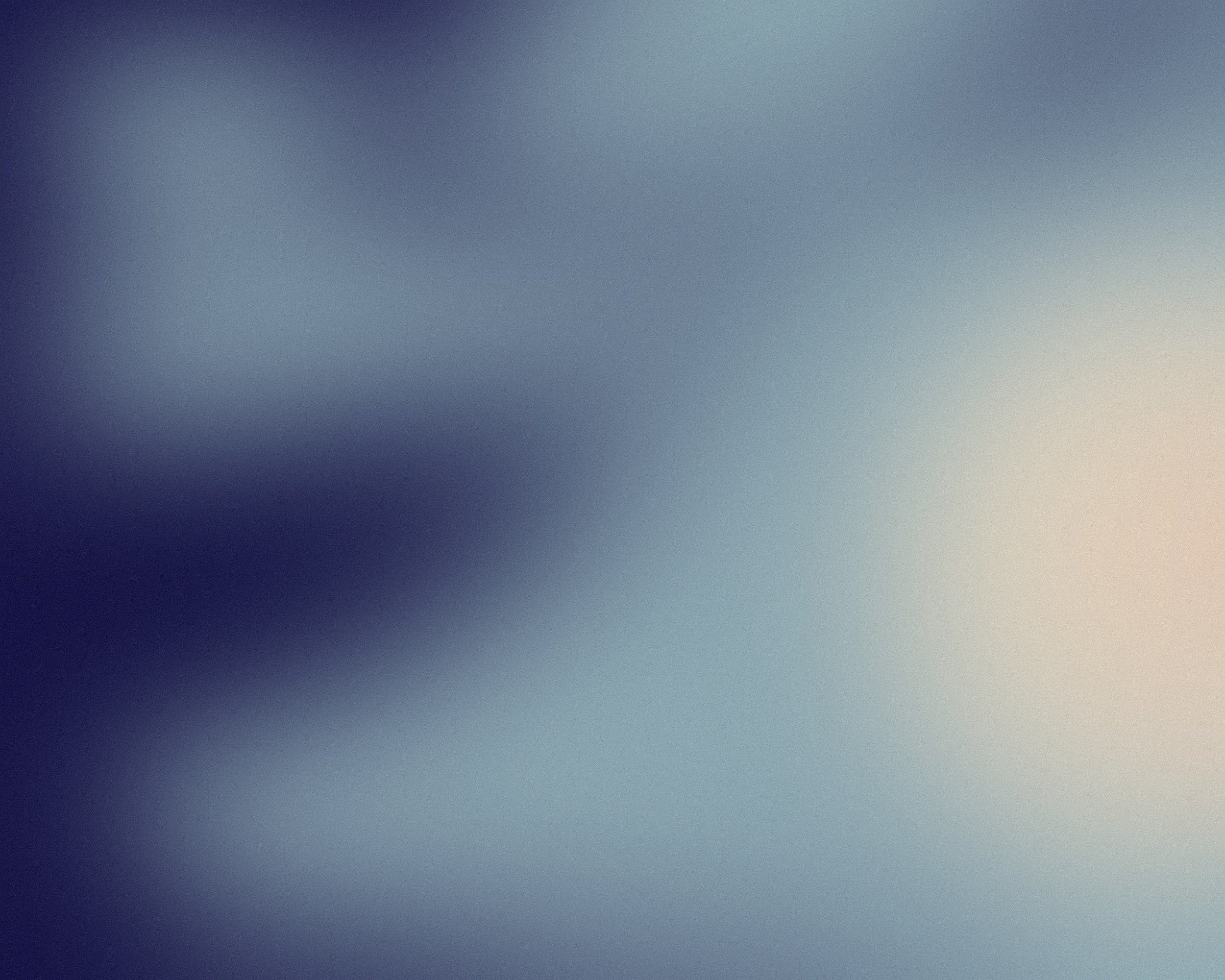 Blurred abstract background with shades of blue, gray, and white.
