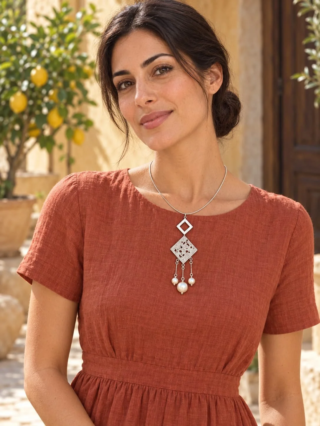 Ornate silver pearl necklace on terracotta.jpg