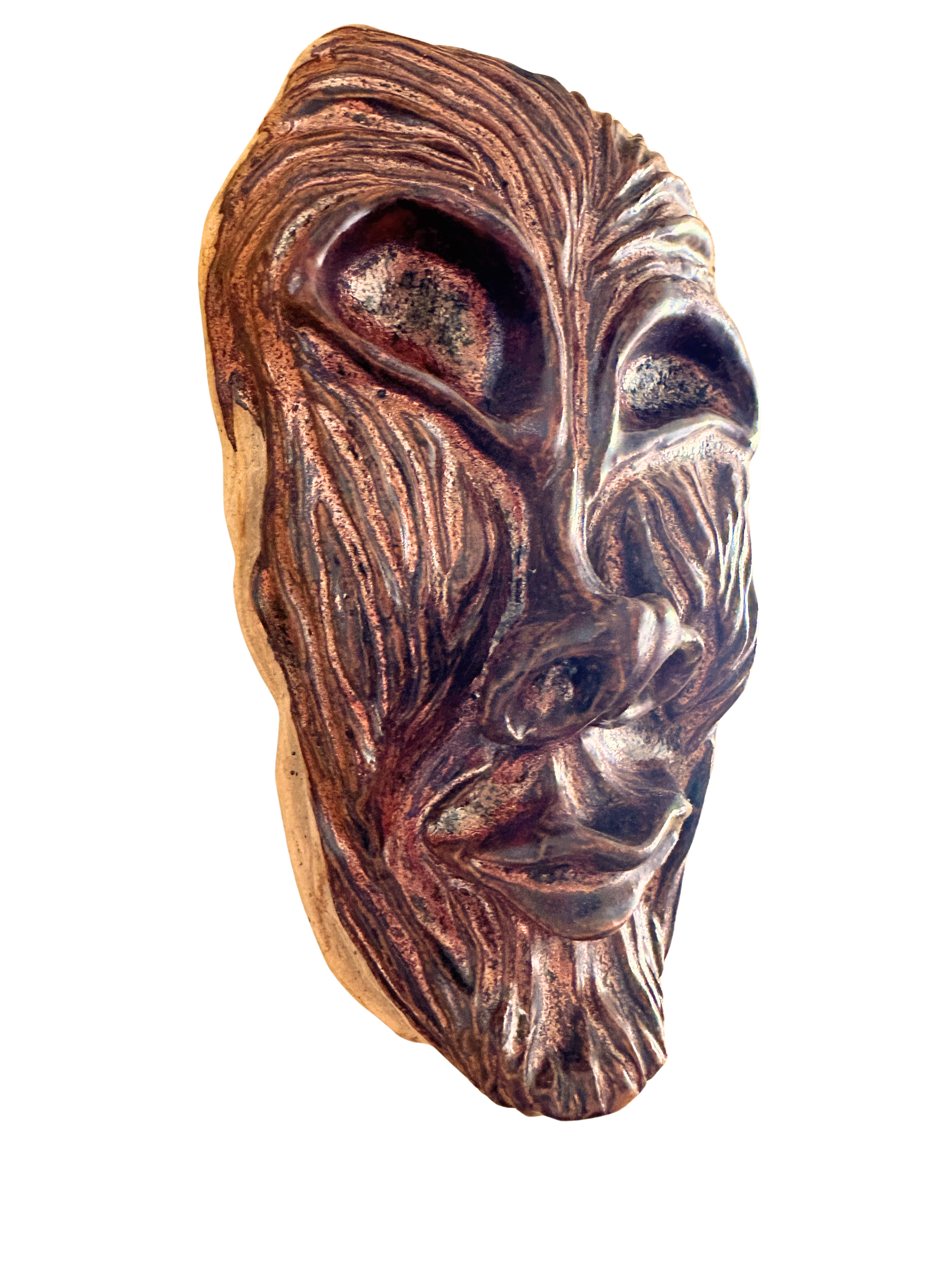 eyeless ceramic mask with gentle smile and coppery glaze. face contoured to resemble a tree