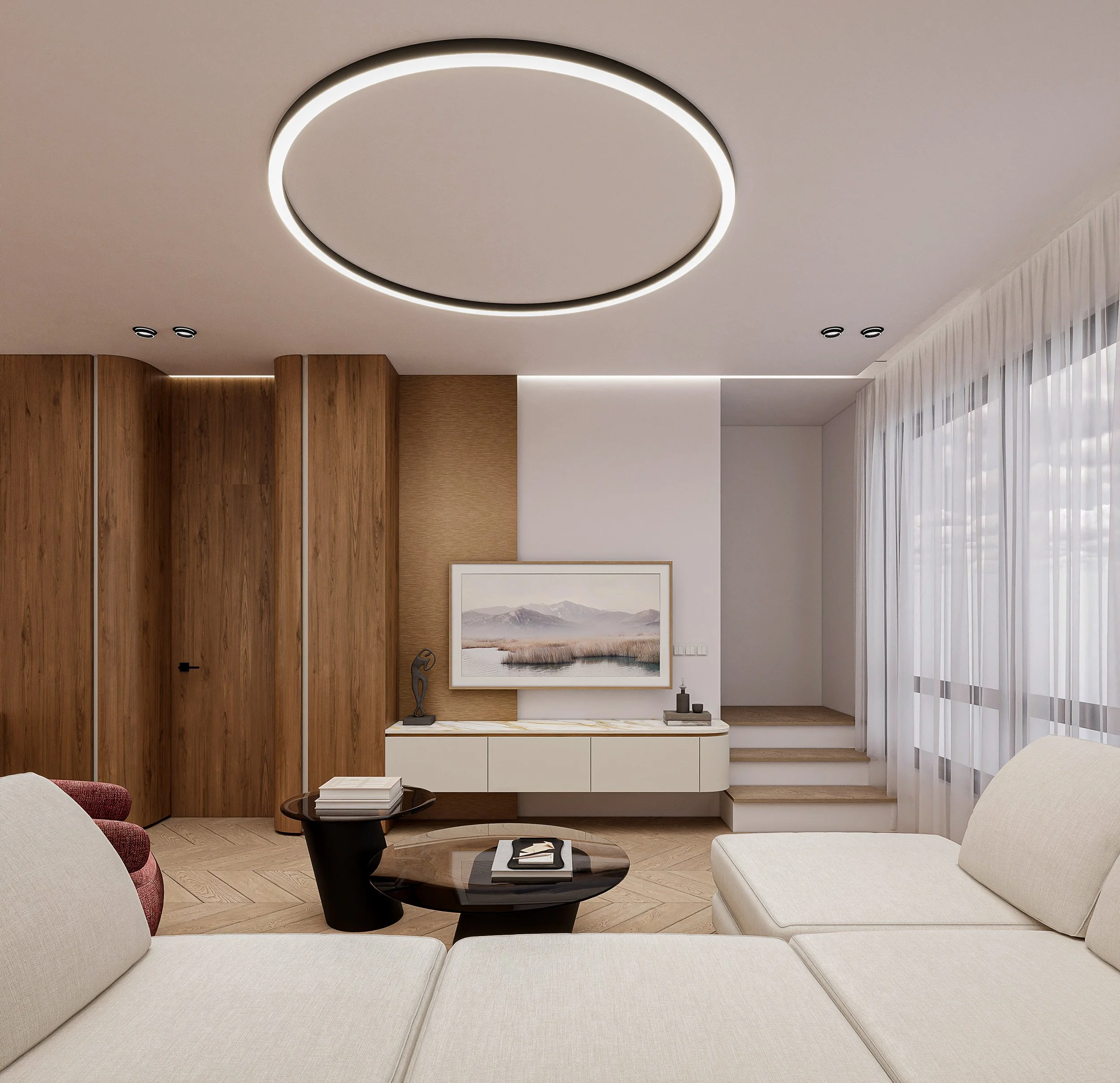 Modern living room with a circular ceiling light, beige sectional sofa, round dark wood coffee table, white entertainment unit, and a staircase with curtains by large windows.