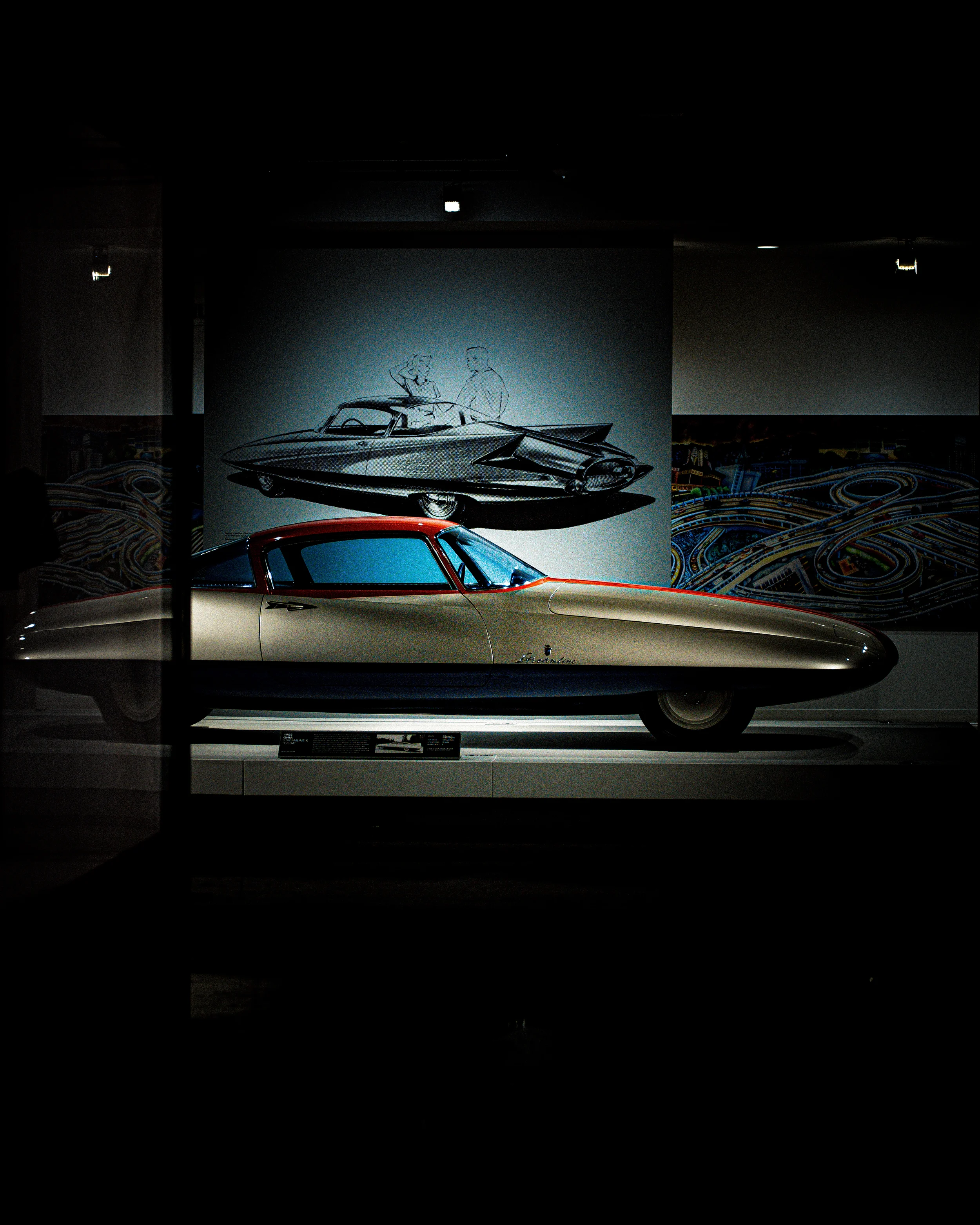 Voiture futuriste d'exposition, avec croquis de design derrière, dans un musée, ambiance sombre.