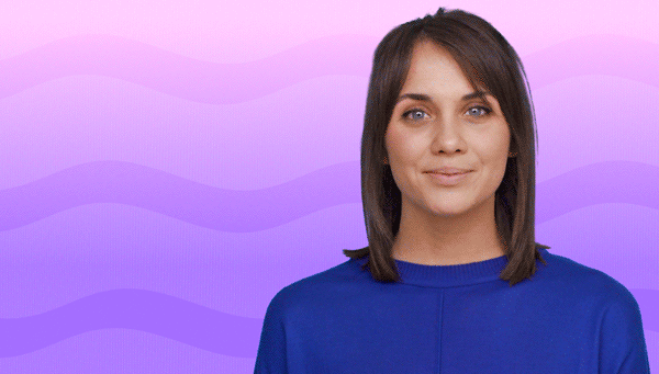 A woman with shoulder-length brown hair wearing a blue top, standing against a pastel purple and pink wavy background.