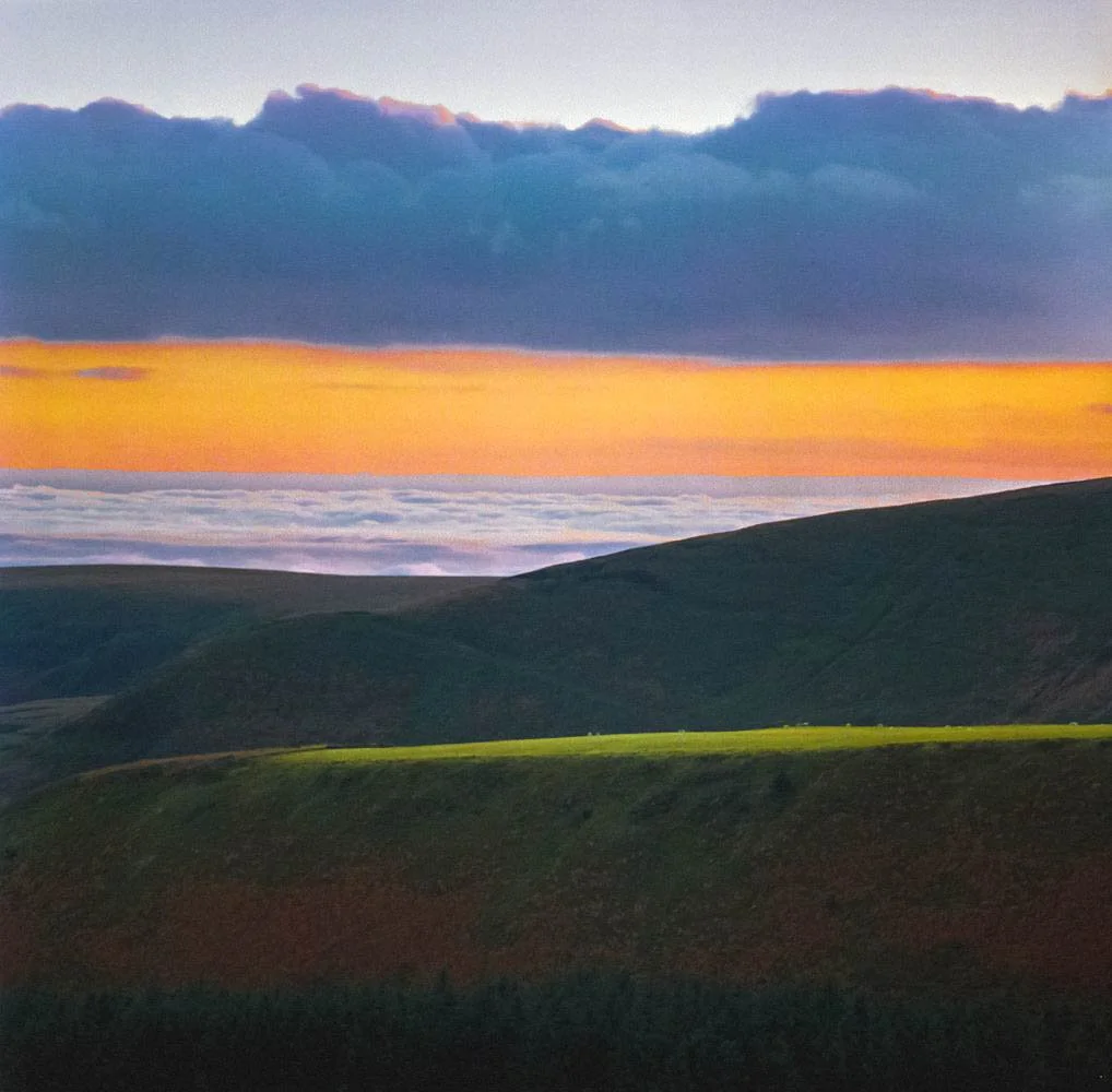 Bright light across a mountain ridge guiding the viewer through the landscape towards warm sunset colours
