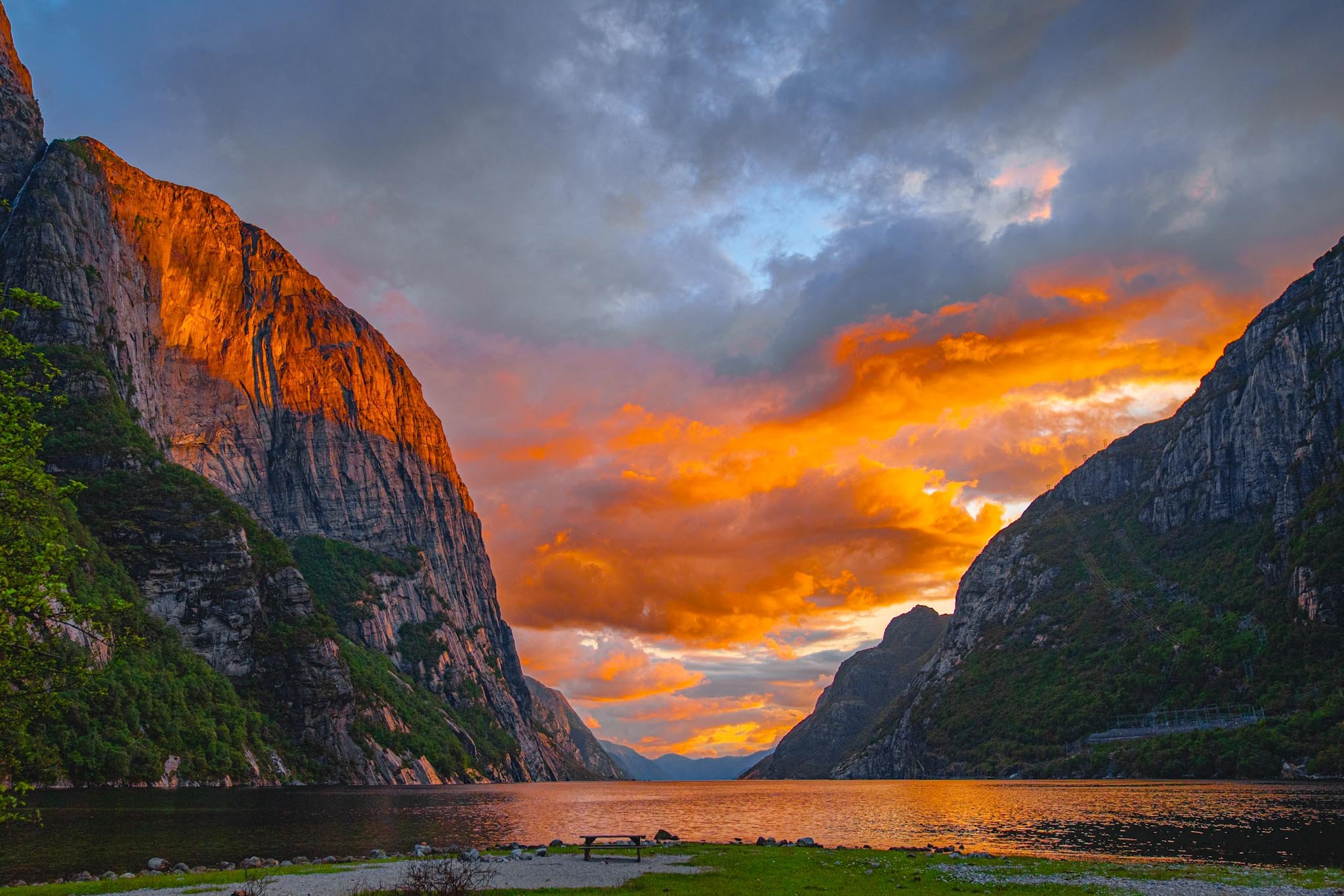 Fjord in Norway at sunset with strong directional light hitting one cliff while the rest remains in shadow
