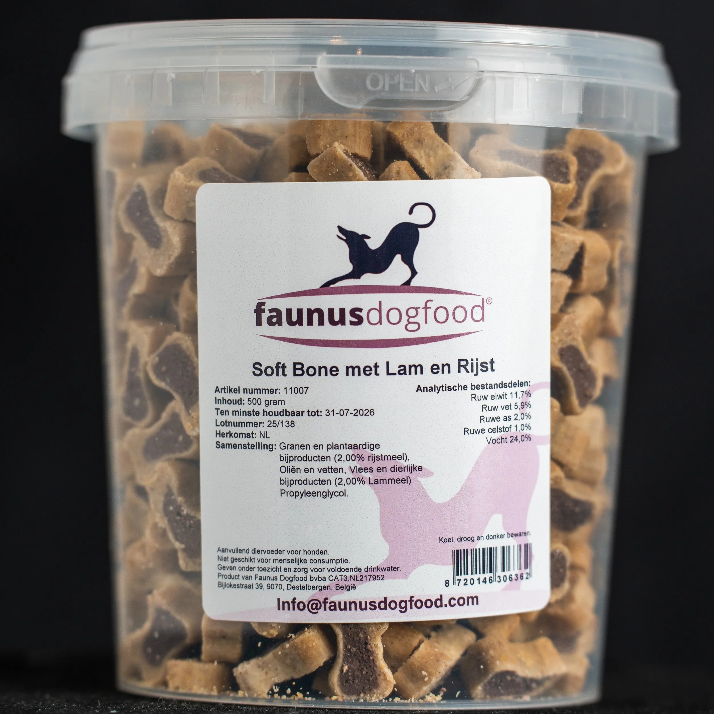 Clear plastic container of dog treats shaped like bones with a white label displaying the Faunus Dog Food logo and product information in Dutch.