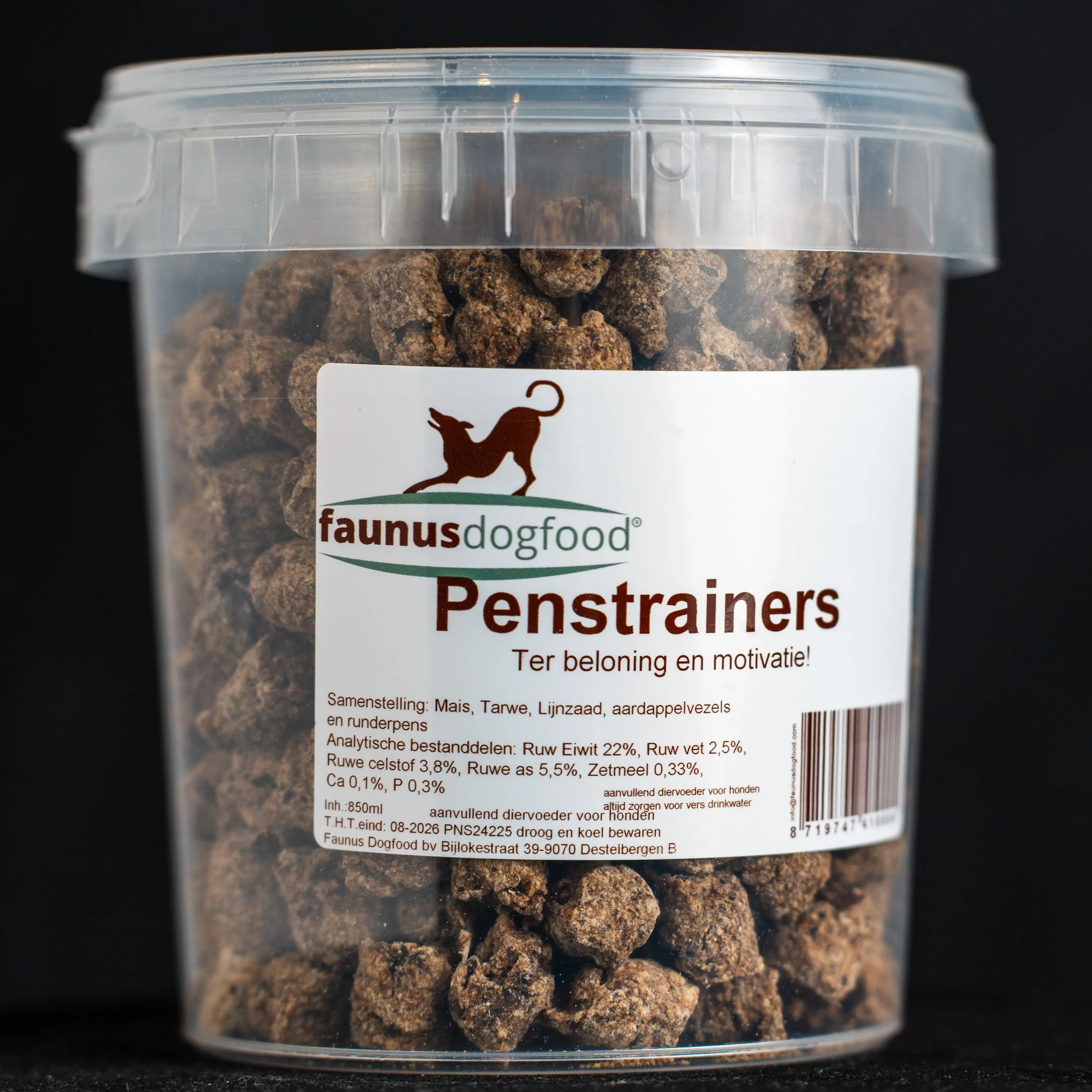 Clear plastic container of dog food called Penstrainers by Faunus, containing small brown pet treats, with a label detailing ingredients, nutrition, and manufacturer information.