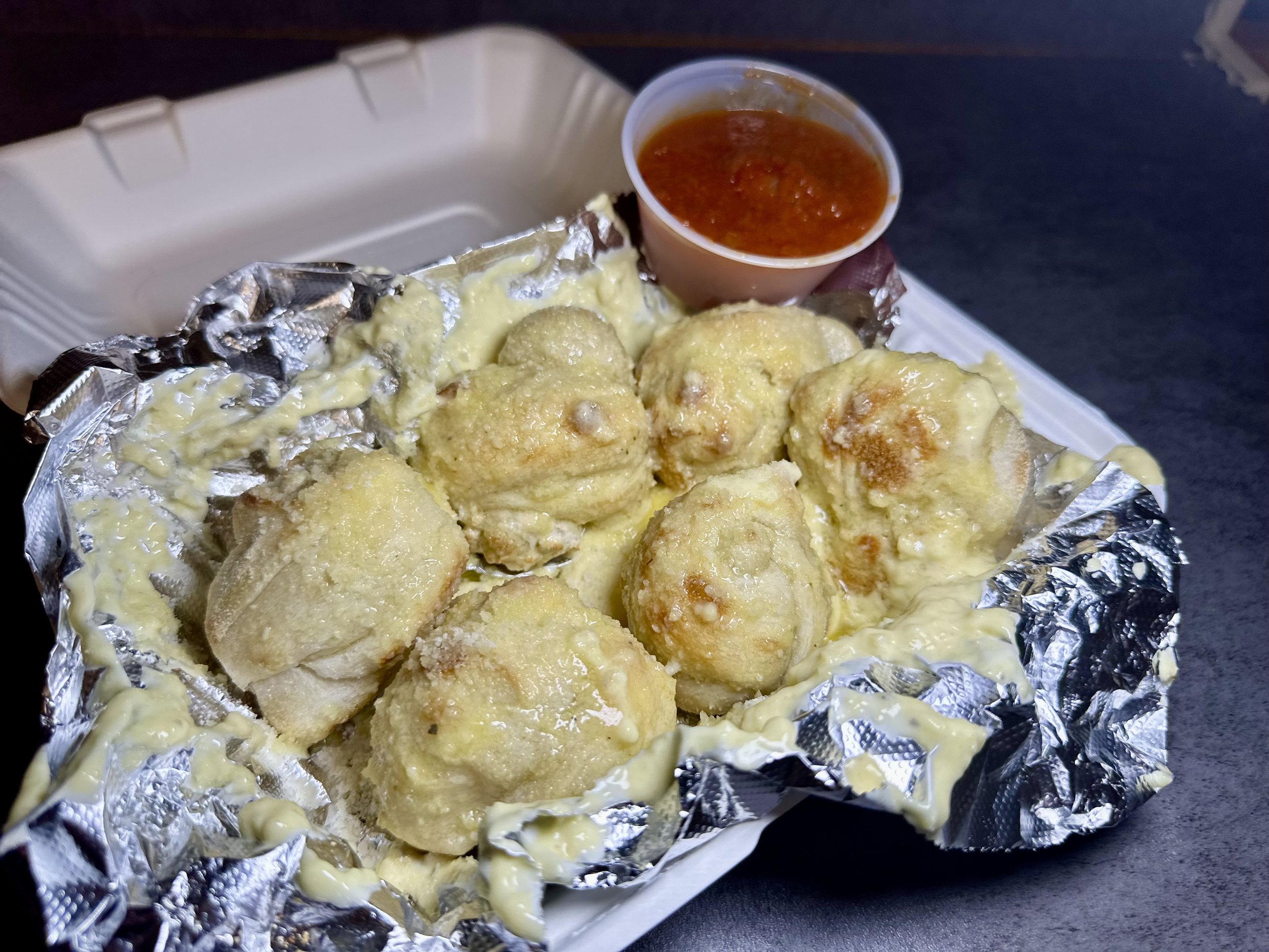Footlong mozzarella sticks topped with melted cheese, served with marinara sauce