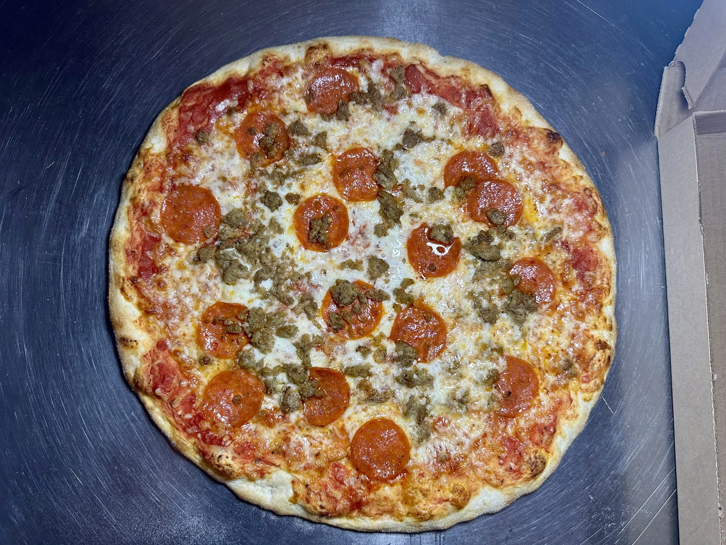 Pepperoni and sausage pizza in a cardboard box
