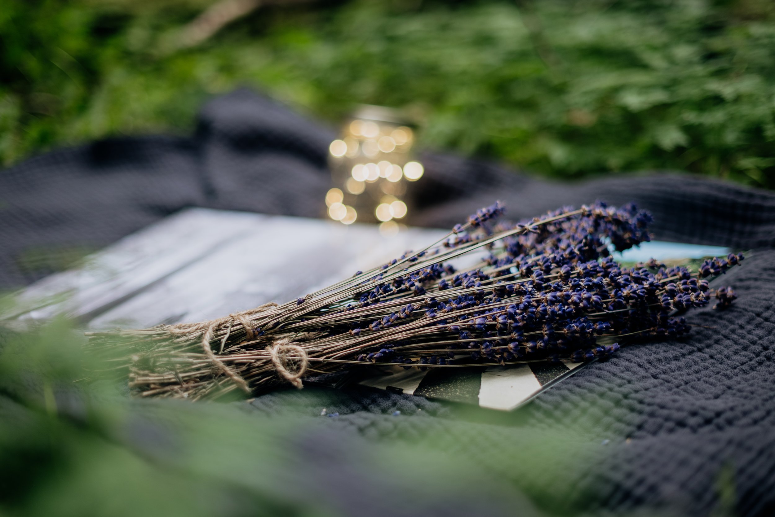 A bundle of dried lavender flowers lying on a black textured cloth.