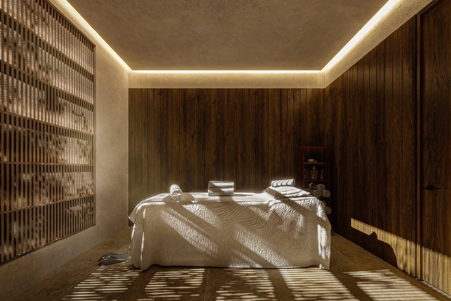 Habitación con paredes de madera, cama con sábanas blancas, toallas enrolladas y prendas dobladas. La luz del sol crea sombras en la cama y el piso, y hay una pequeña estantería con toallas y objetos en la esquina derecha.