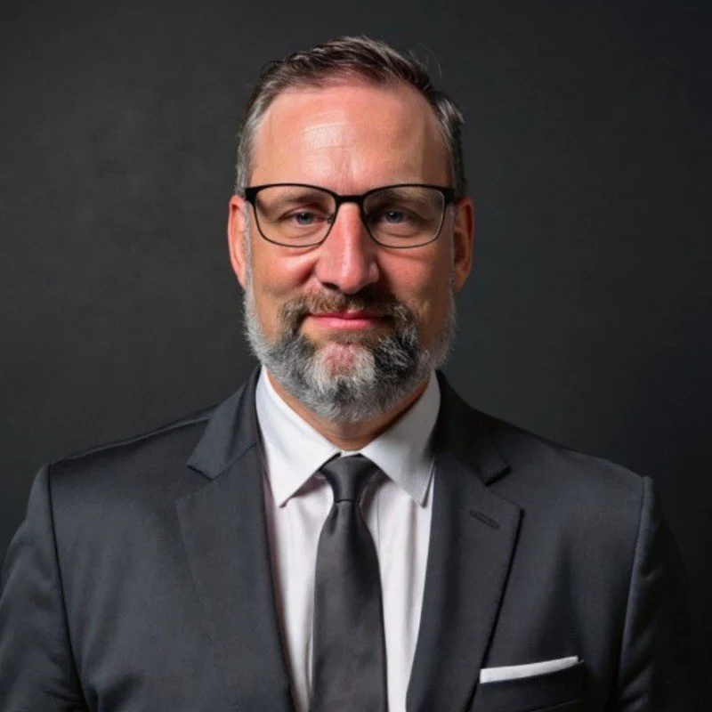 Nathan Rommel in suit and tie, professional headshot
