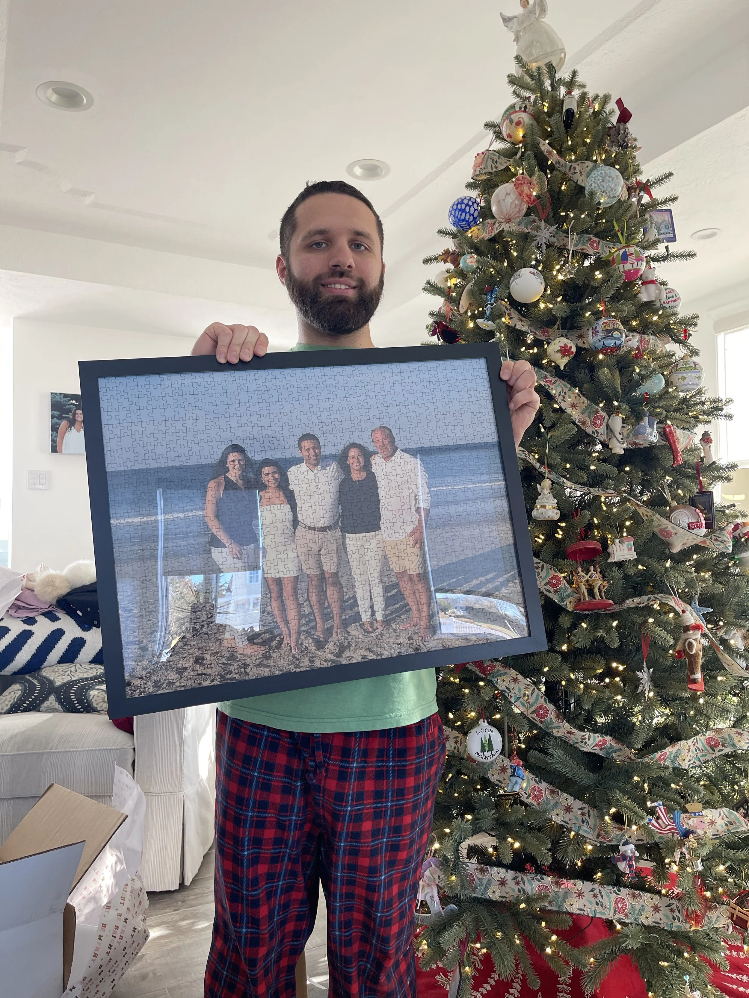Jack Brait, aka Jack Of Puzzles, holding a puzzle be created and bought from PuzzleYou of him, his parents, and his two sisters Gabi and Bella