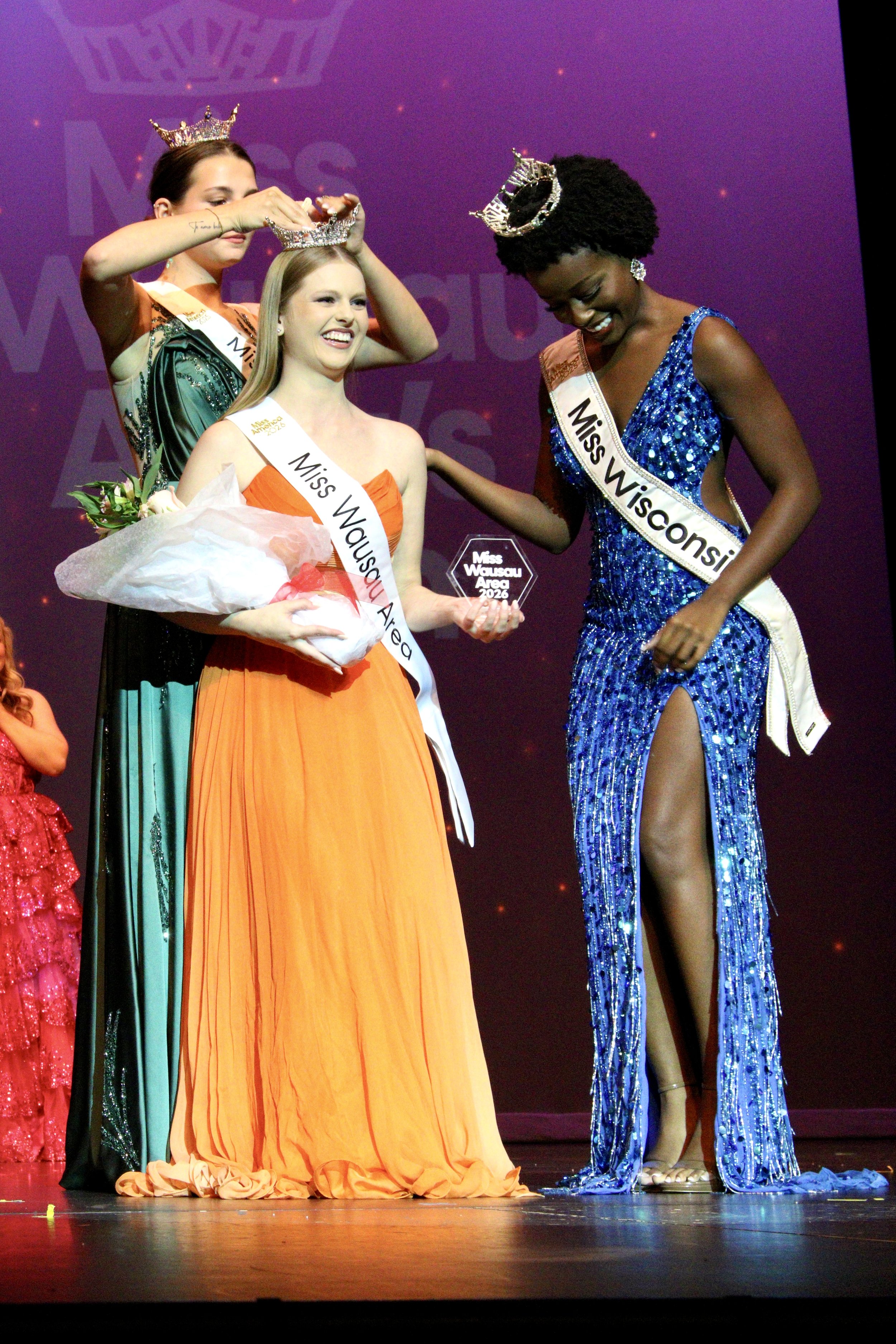 Janae Bond being crowned Miss Wausau Area 2026 on stage during the pageant, with other contestants present.
