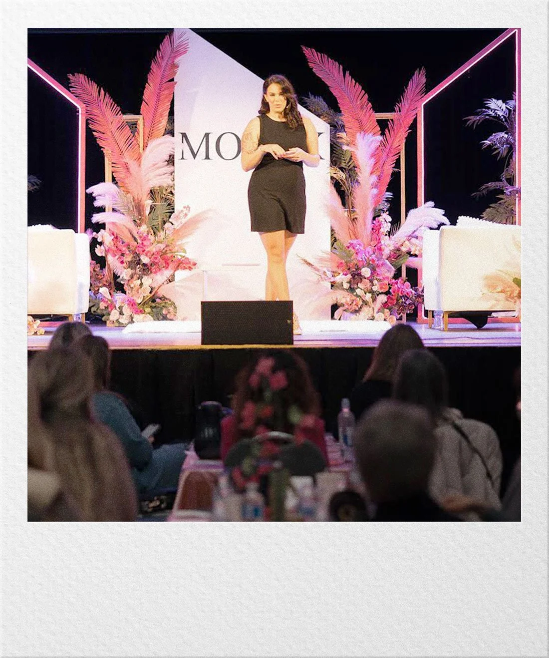 Ariel speaking on stage at a fertility conference.