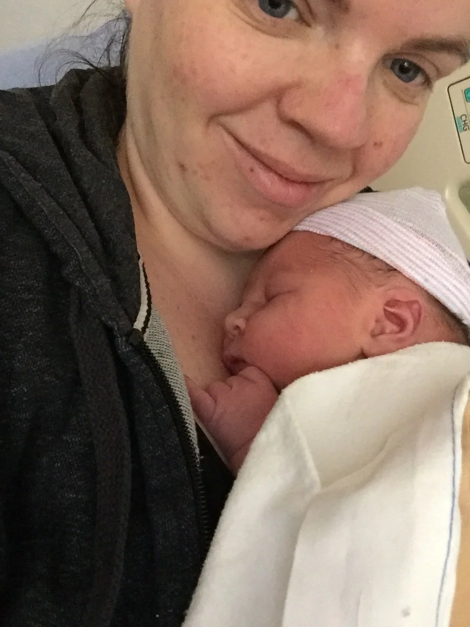 Ashley holding her newborn son close in the hospital just after birth