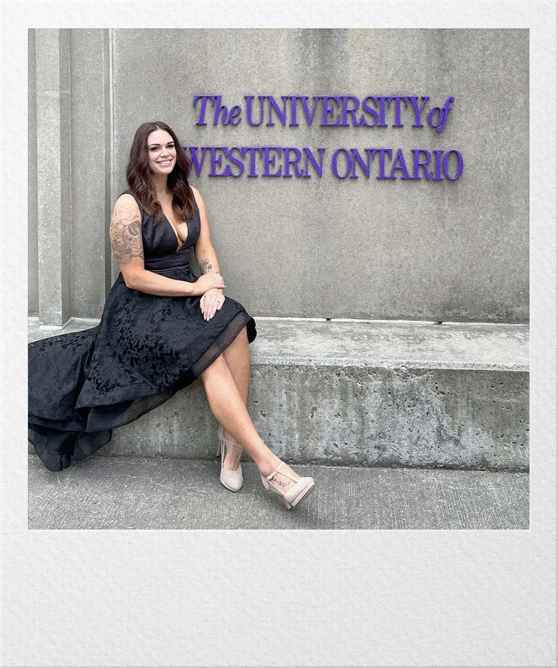 Ariel standing outside a university building on graduation day.