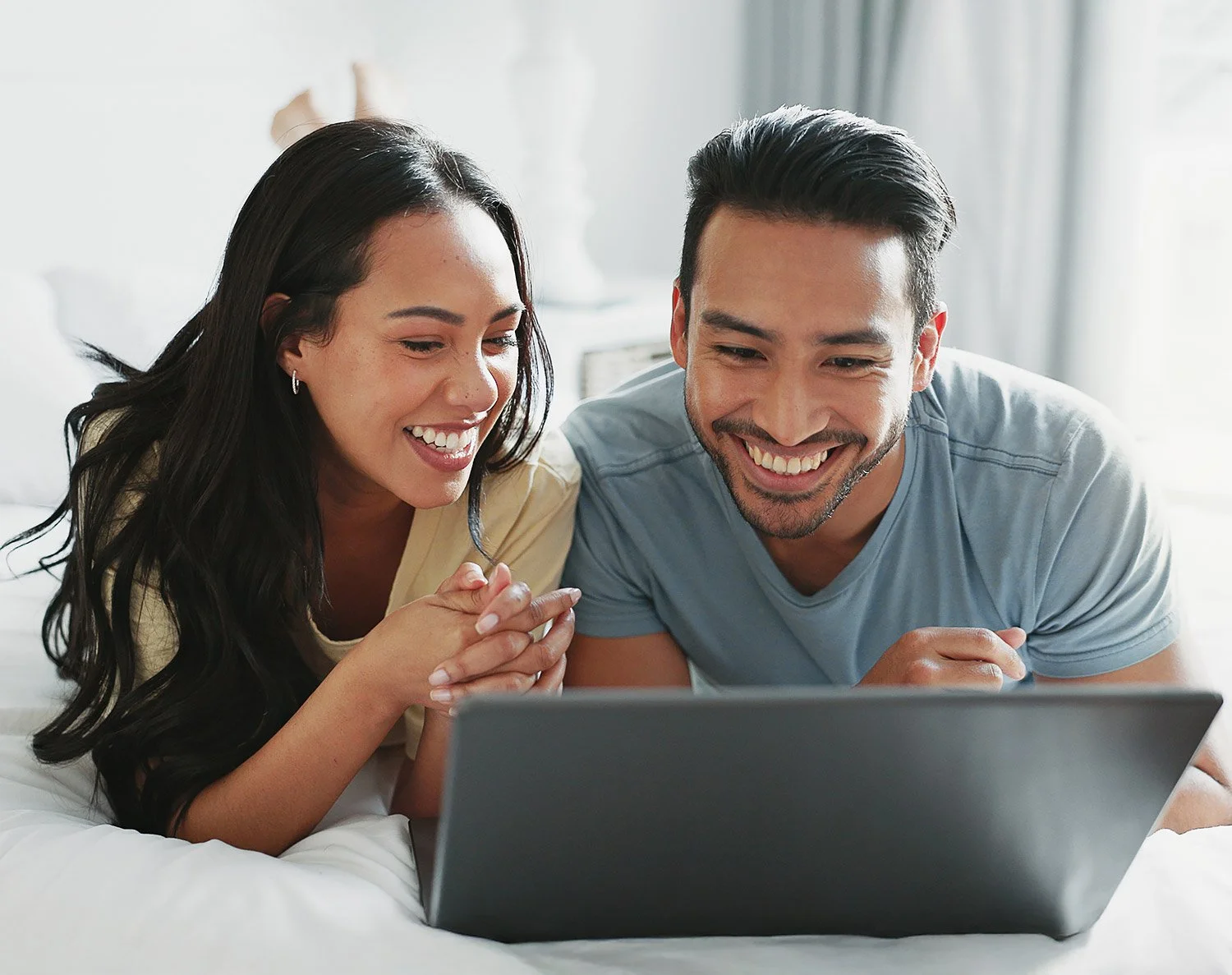 Two intended parents reviewing information together on a laptop during an independent surrogacy planning process.
