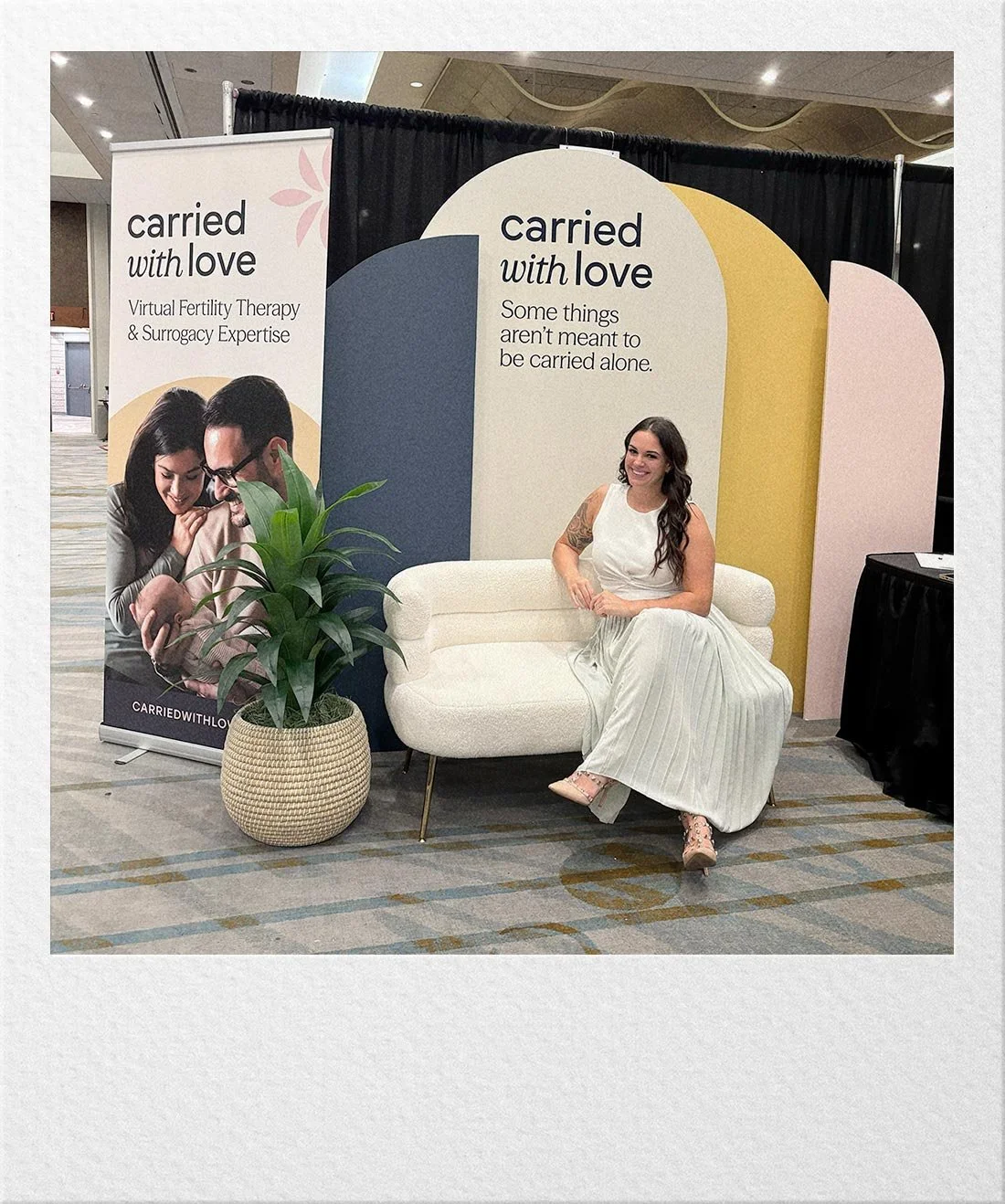 Ariel seated at a conference booth representing Carried With Love.