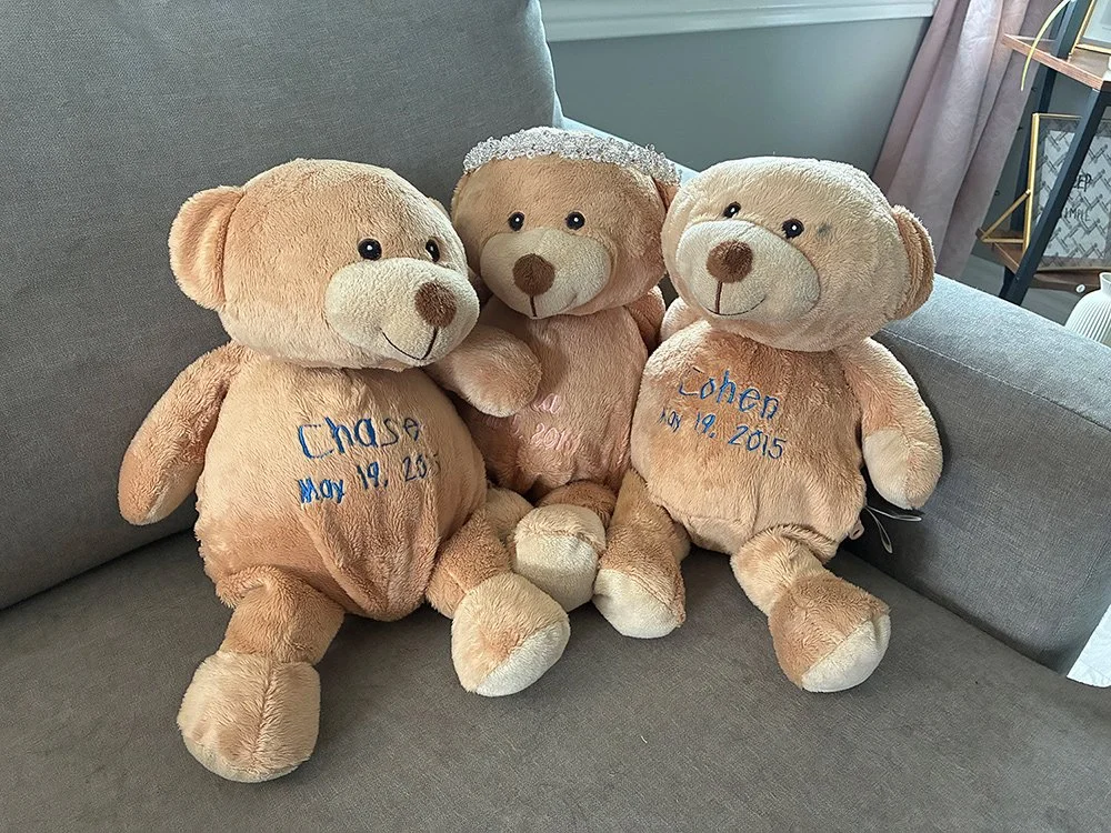 Three teddy bears embroidered with the names and dates of Ashley's stillborn babies.