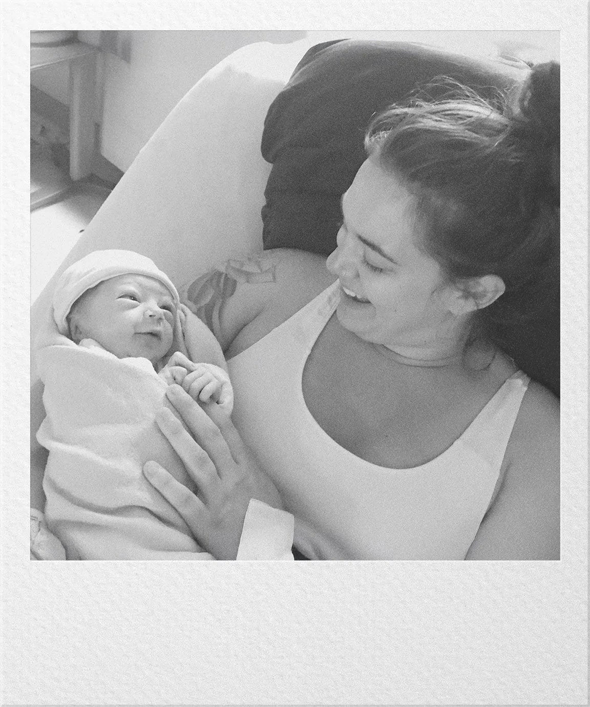 A newborn baby held by an adult shortly after birth.