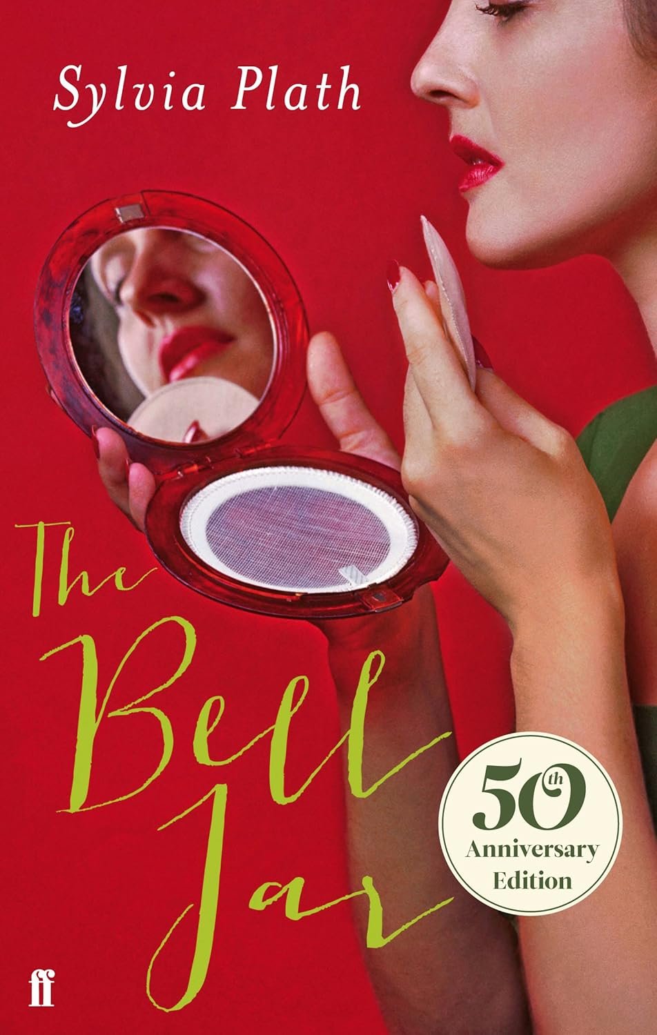 The cover of a book called 'The Belle Jar' by Sylvia Plath, featuring a woman with red lipstick looking into a mirror, with a red background and a white label that reads '50th Anniversary Edition'.