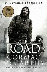 Cover of the book 'The Road' by Cormac McCarthy featuring a man in dark clothing and a cap, walking through a desolate, snowy landscape with a boy nearby.
