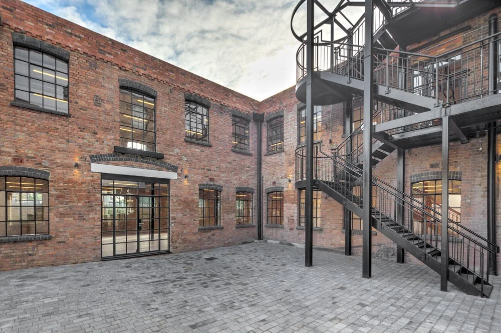 Courtyard with new paving and fire escape and access stair.