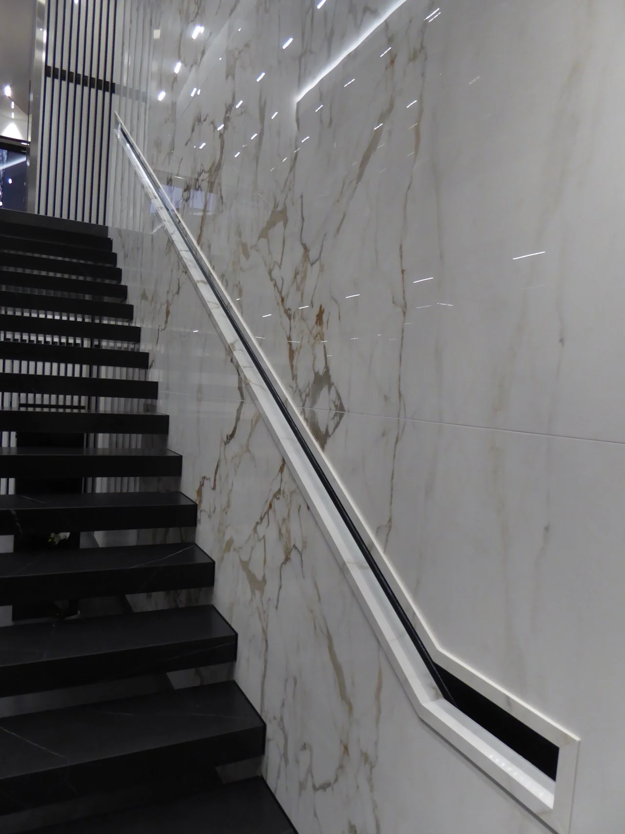 The cantilevered stair and recessed handrail detail