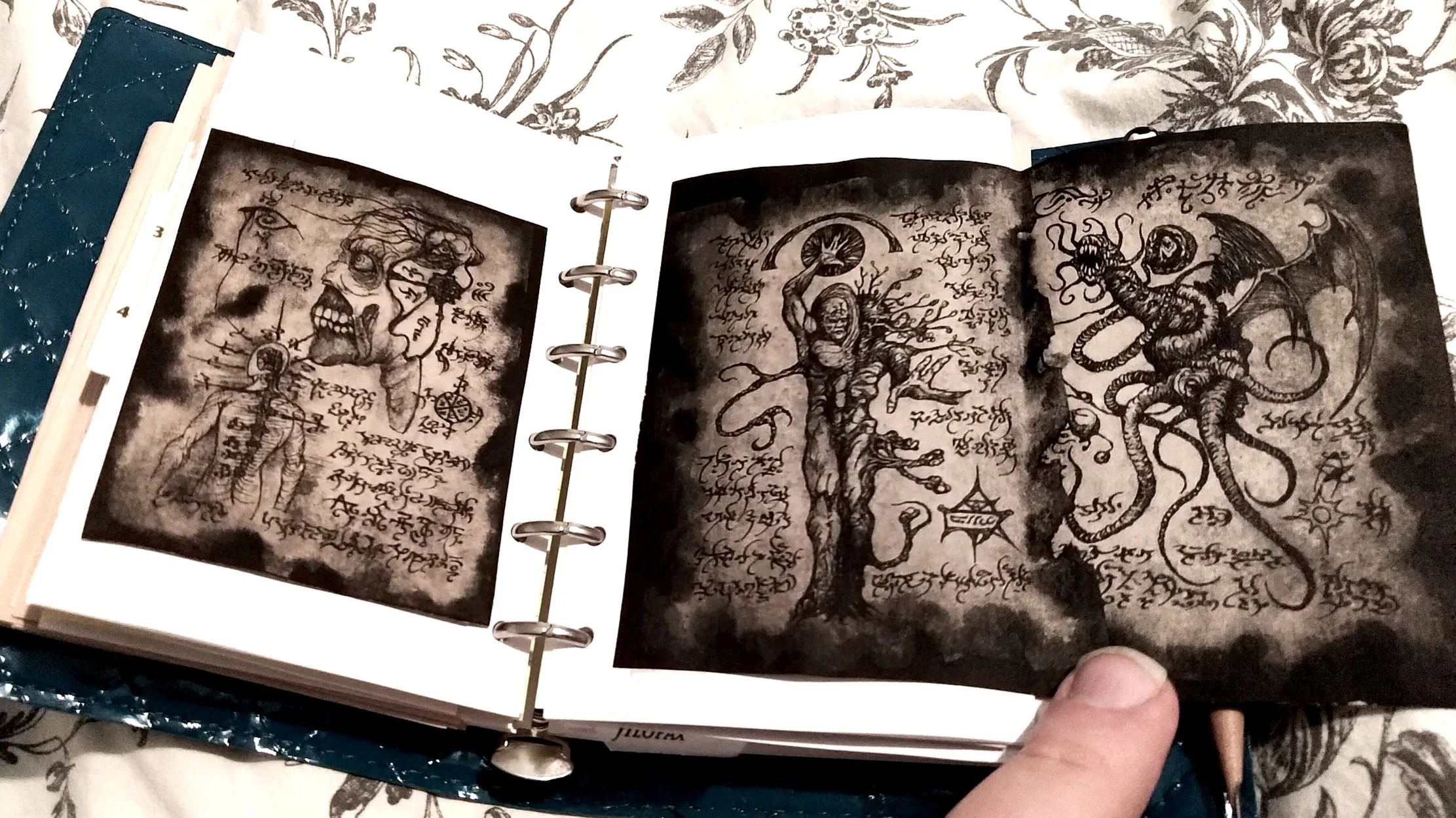 A ring-bound notebook with glued-in pages of a fanciful fantasy text depicting various monsters and described with a made-up script